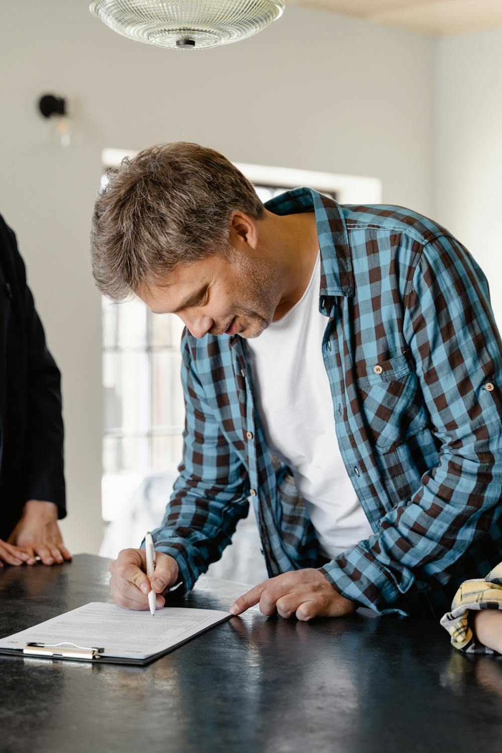 Un hombre firmando papeles | Fuente: Pexels