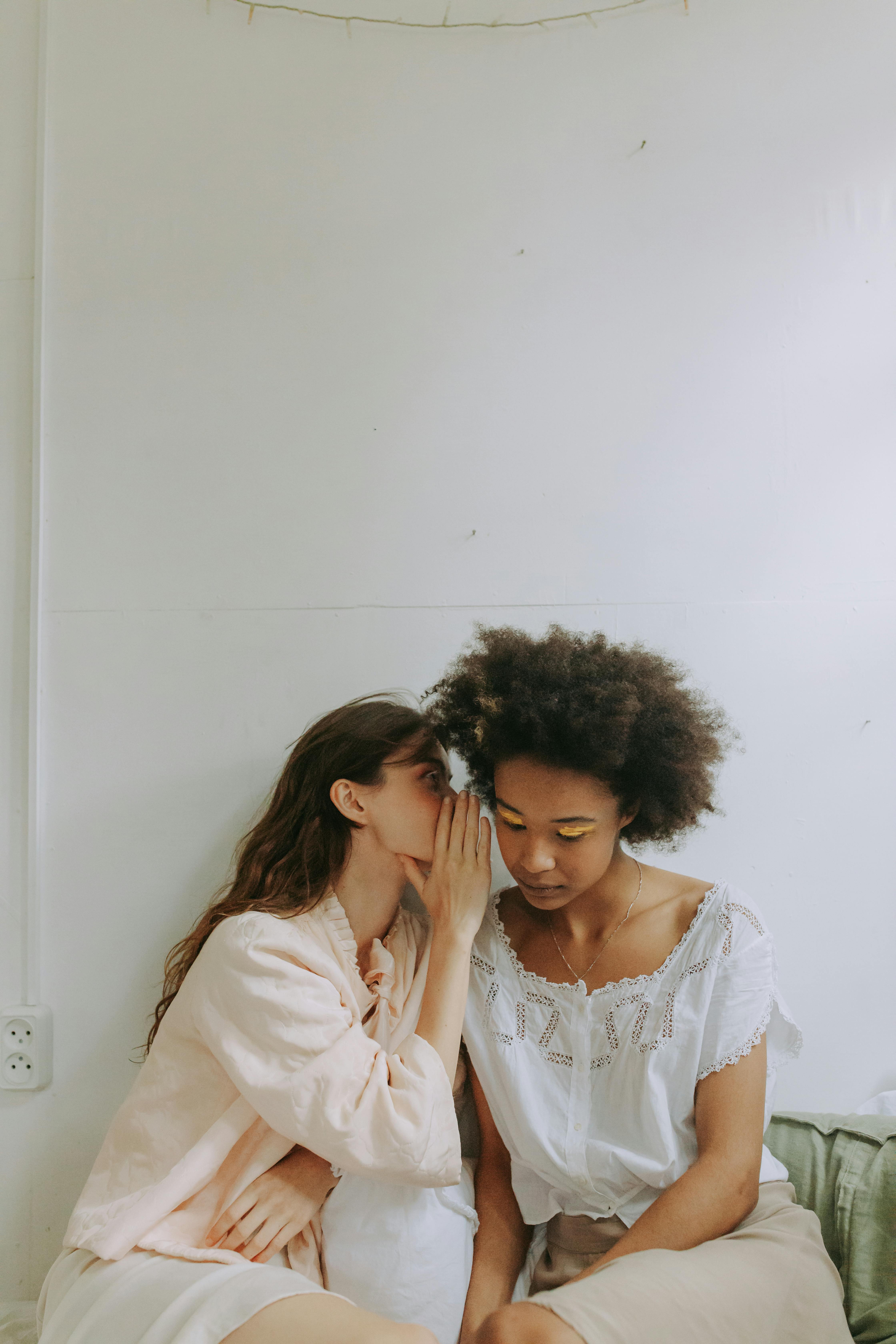 Mujer susurrando algo a otra persona | Foto: Pexels