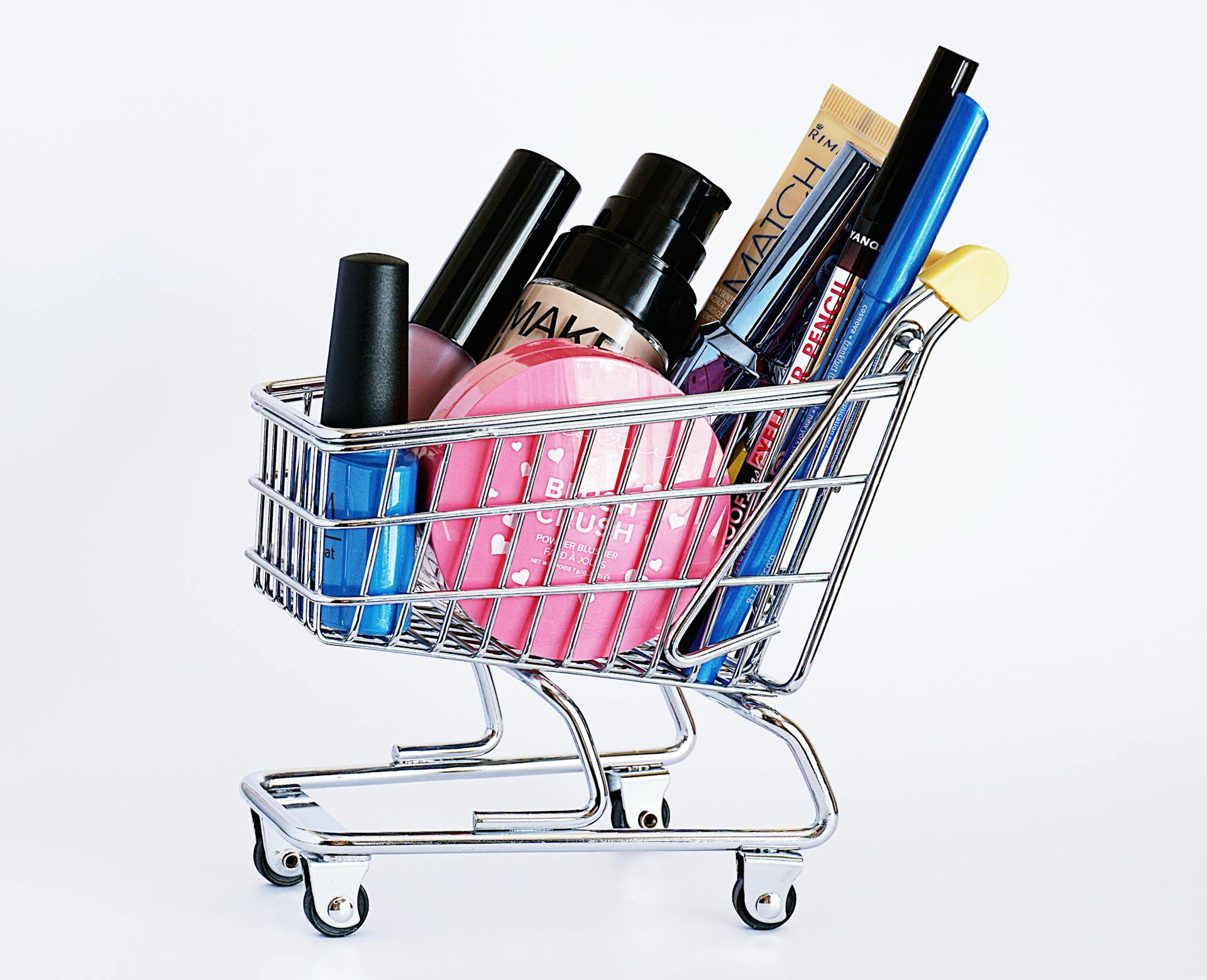 Productos de maquillaje en un mini carrito de la compra | Fuente: Pexels