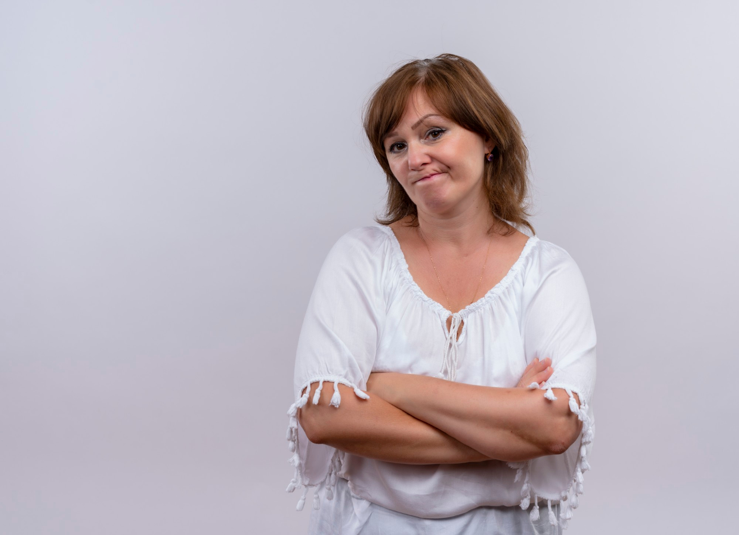 Una mujer pensativa con los brazos cruzados | Fuente: Freepik