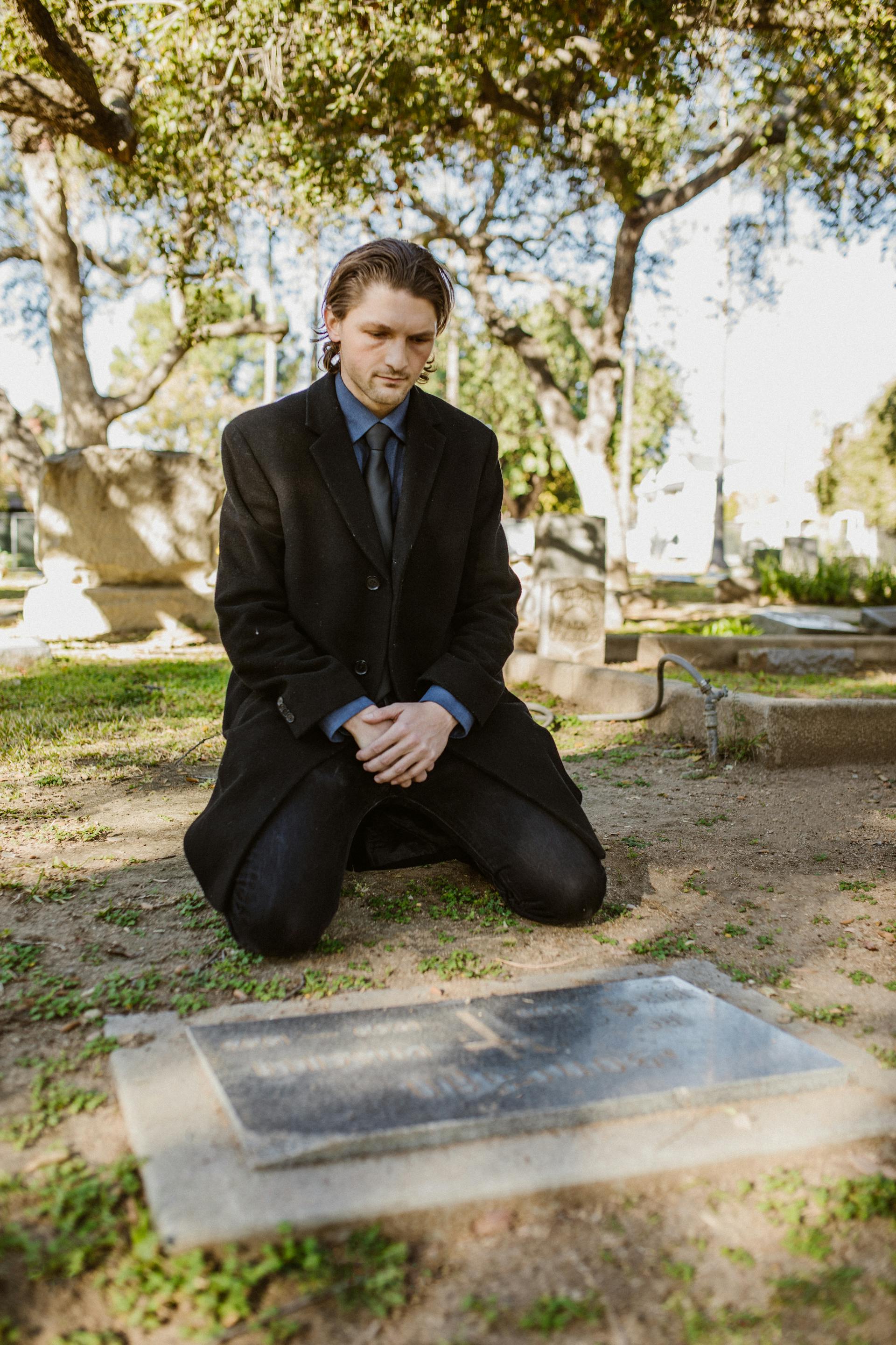 Un joven ante una tumba | Foto: Pexels