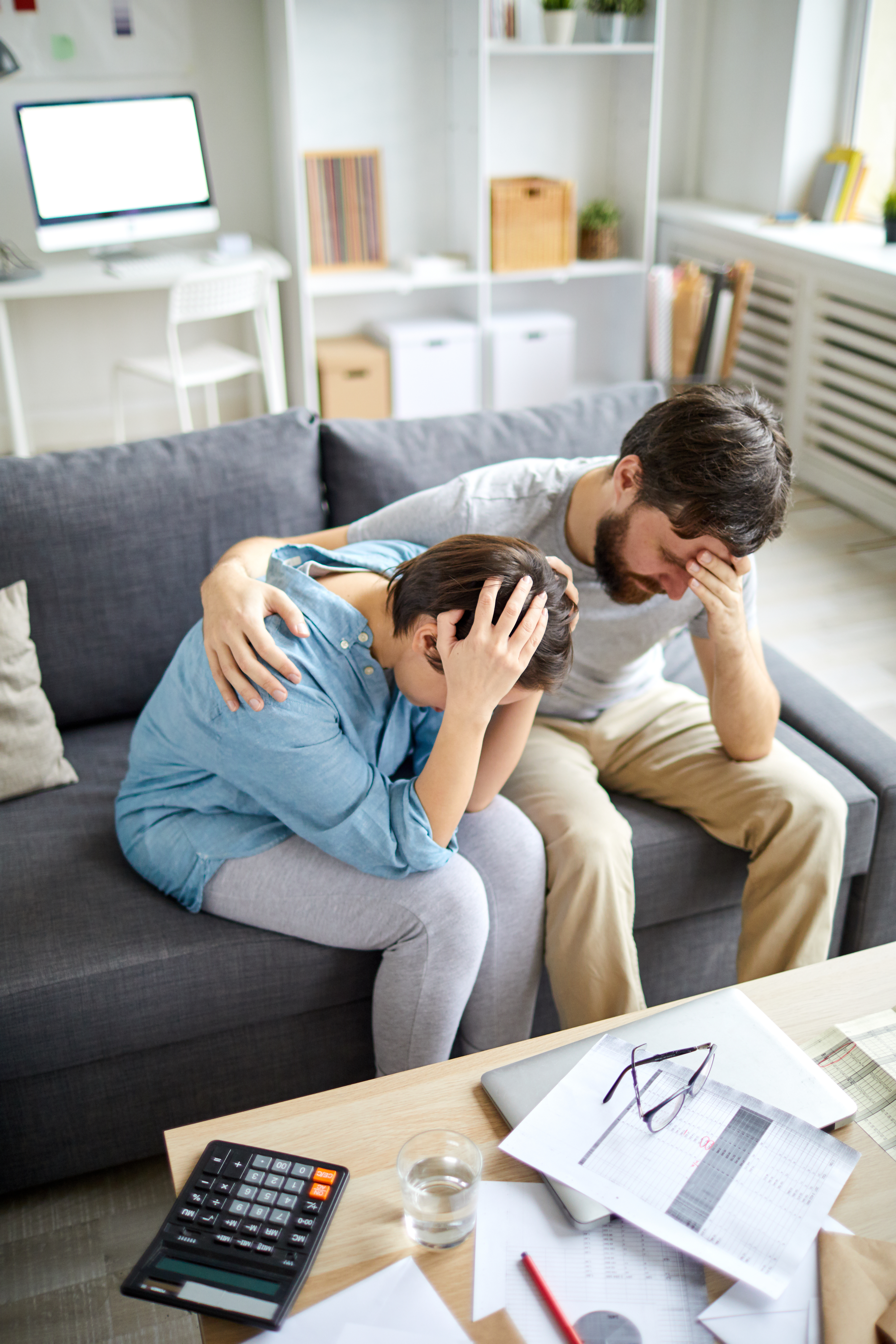 Hombre angustiado rodea con su brazo a una mujer angustiada | Fuente: Shutterstock