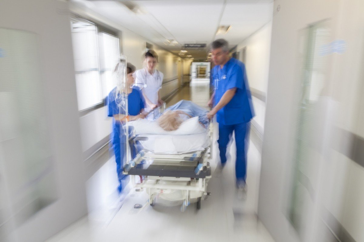 Médicos trasladando a un paciente en camilla por el pasillo de un hospital. | Imagen: PxHere