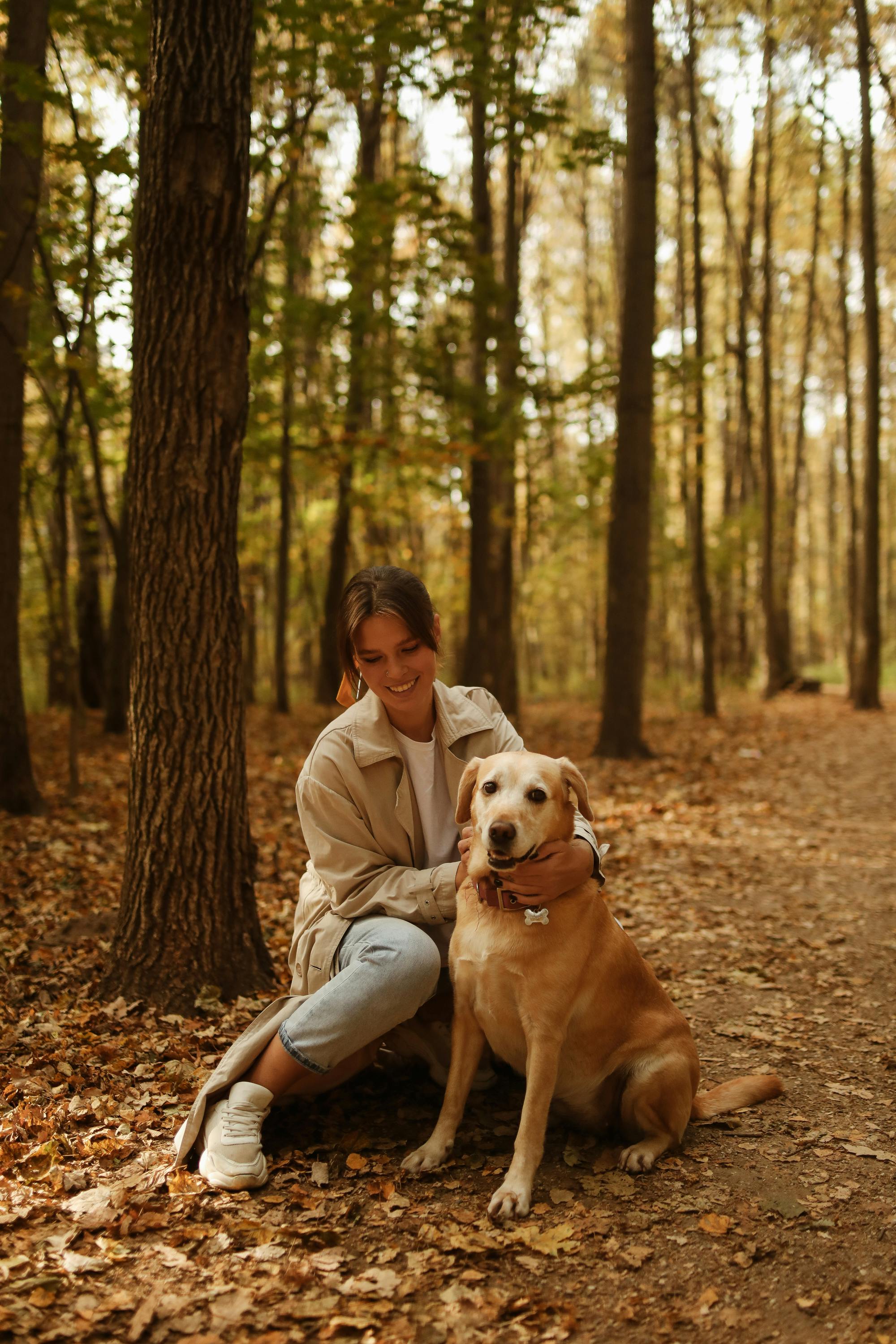 Una mujer sonriente con su perro | Fuente: Pexels