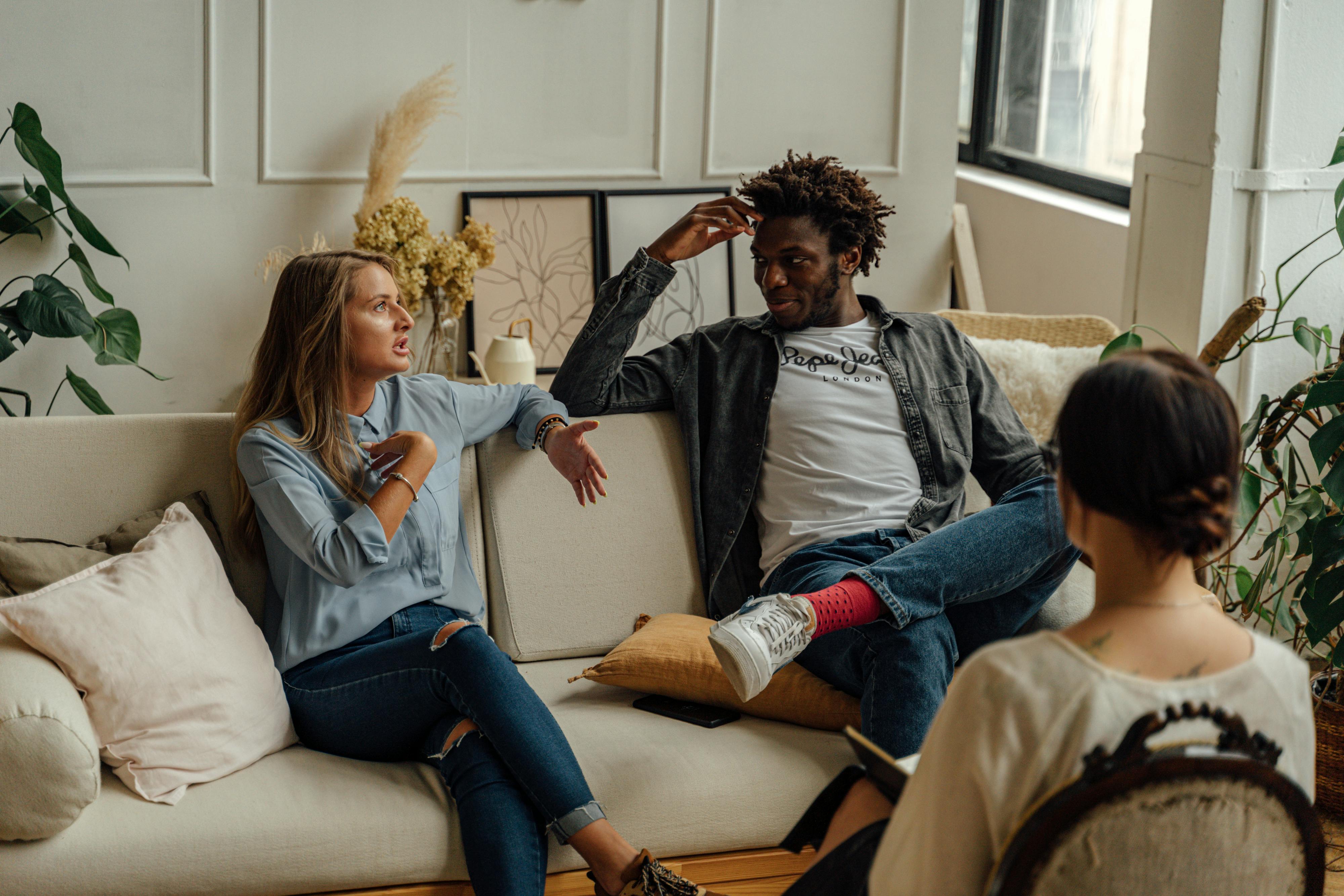 Dos mujeres y un hombre manteniendo una conversación | Fuente: Pexels