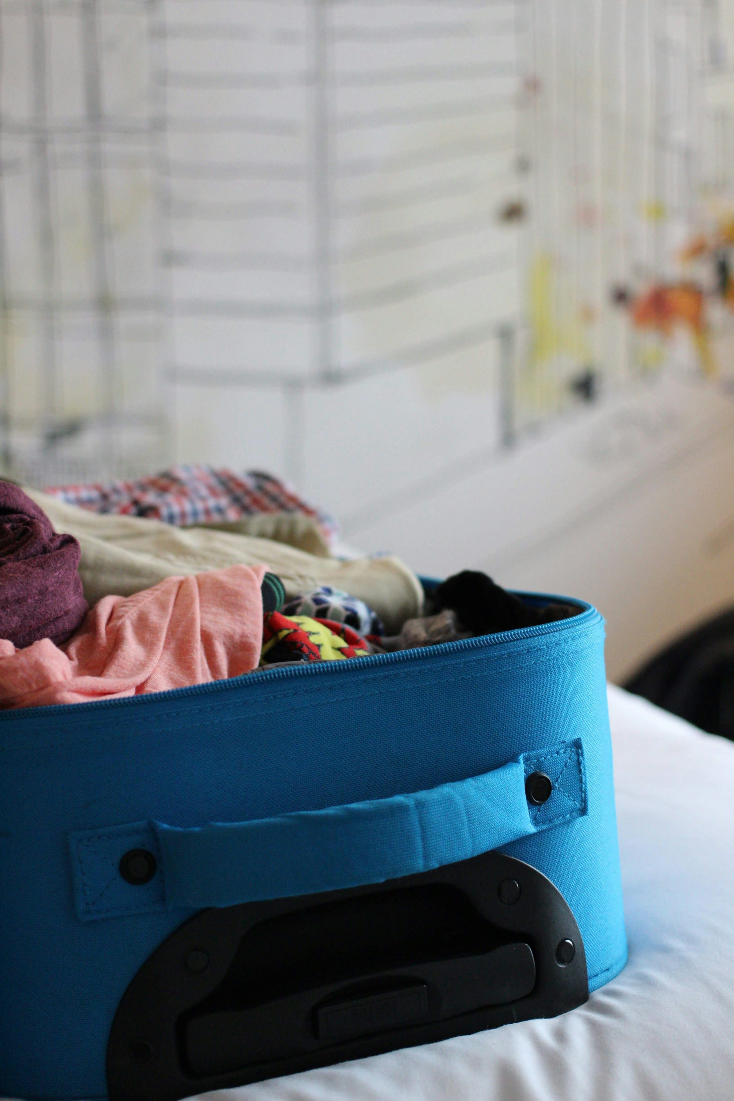 Una maleta abierta sobre una cama | Foto: Unsplash
