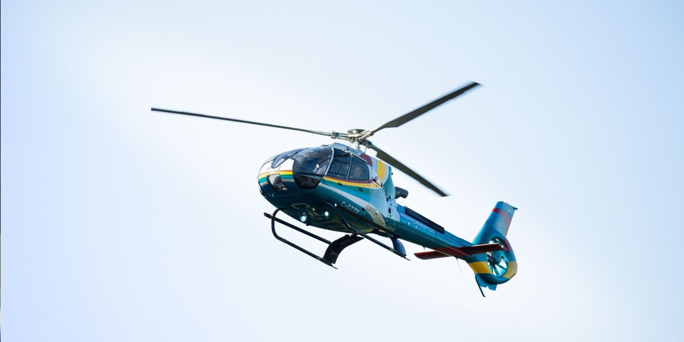 Un helicóptero de colores en vuelo | Fuente: Pexels