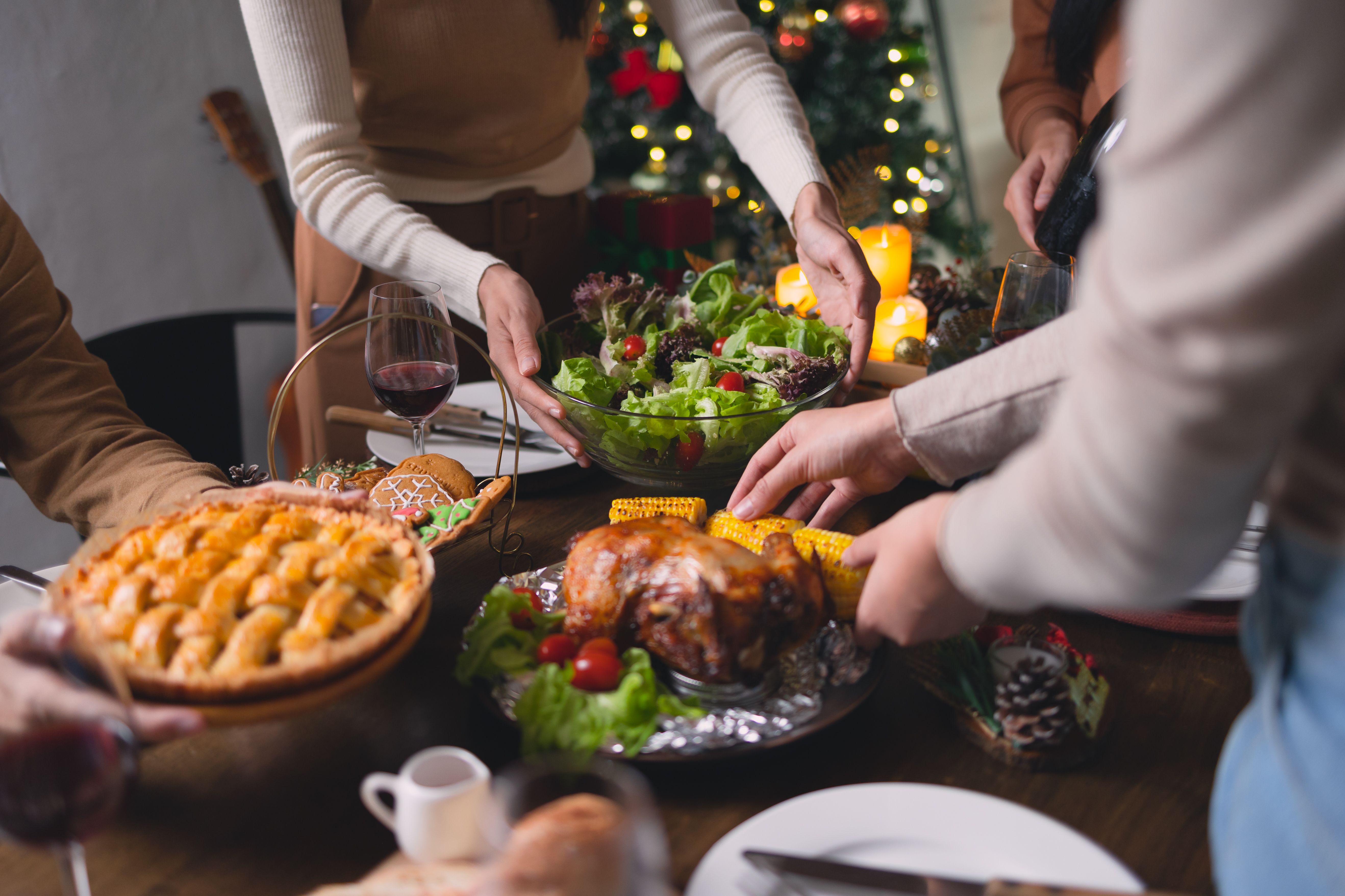 Gente pasando comida alrededor de la mesa | Foto: Getty Images