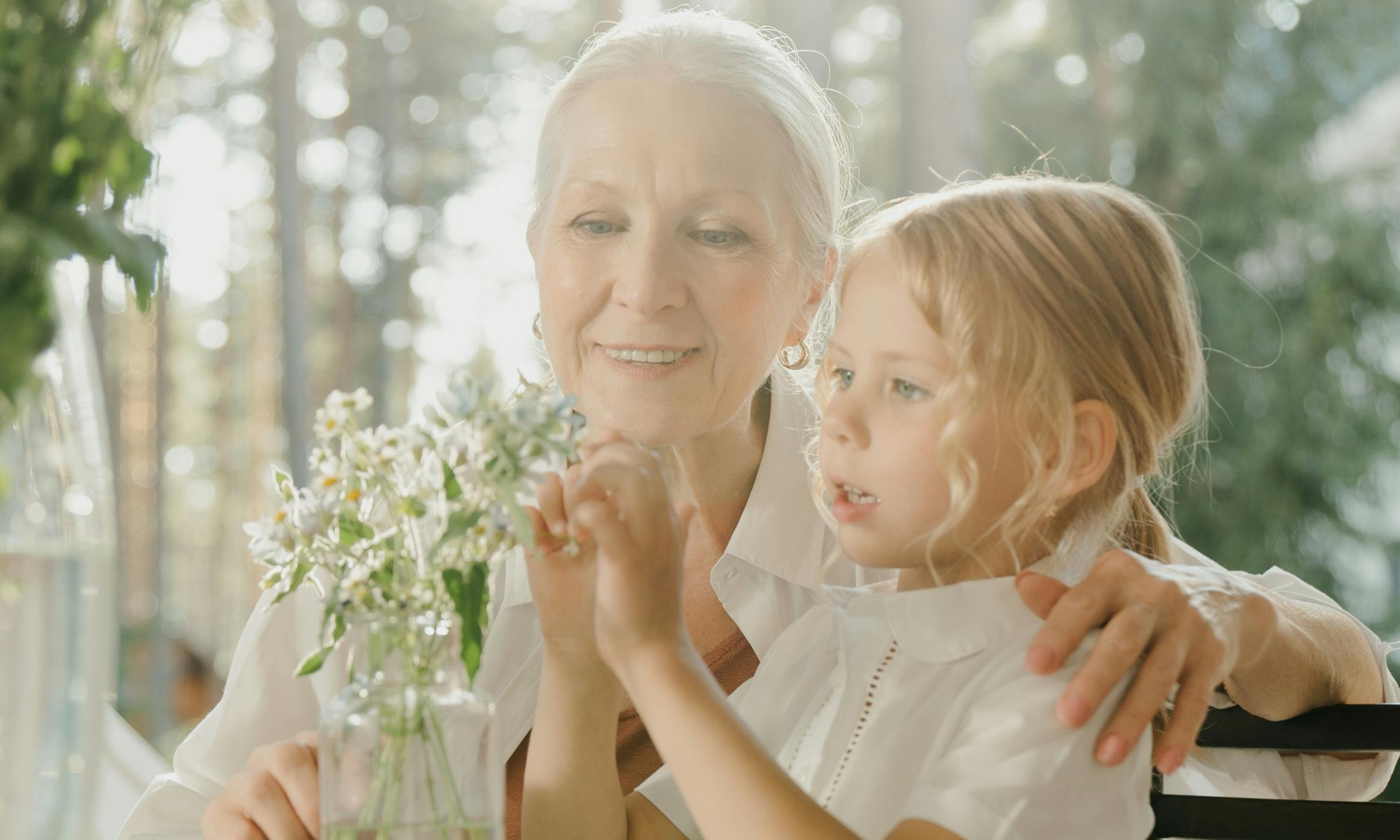 Una anciana y un niño arreglan juntos unas flores | Fuente: Pexels