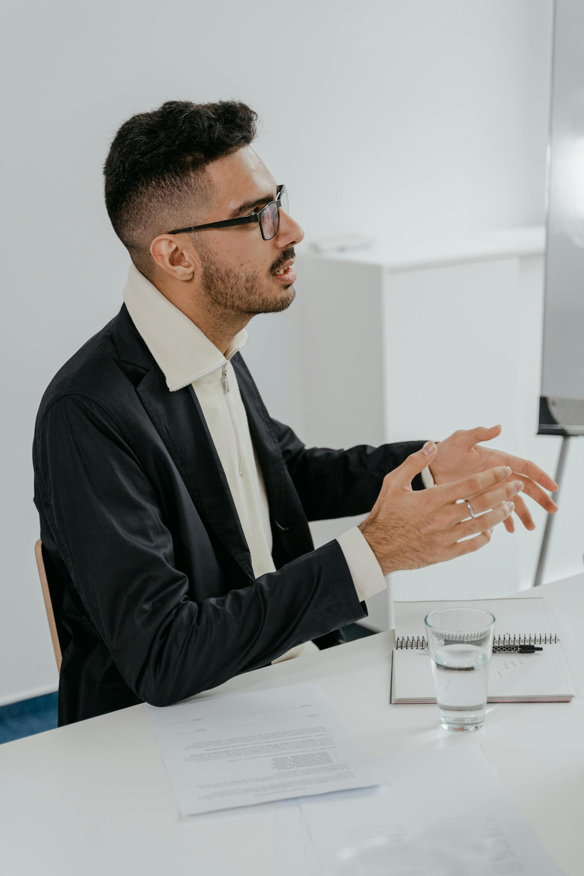 Un hombre habla sentado en una oficina | Fuente: Pexels