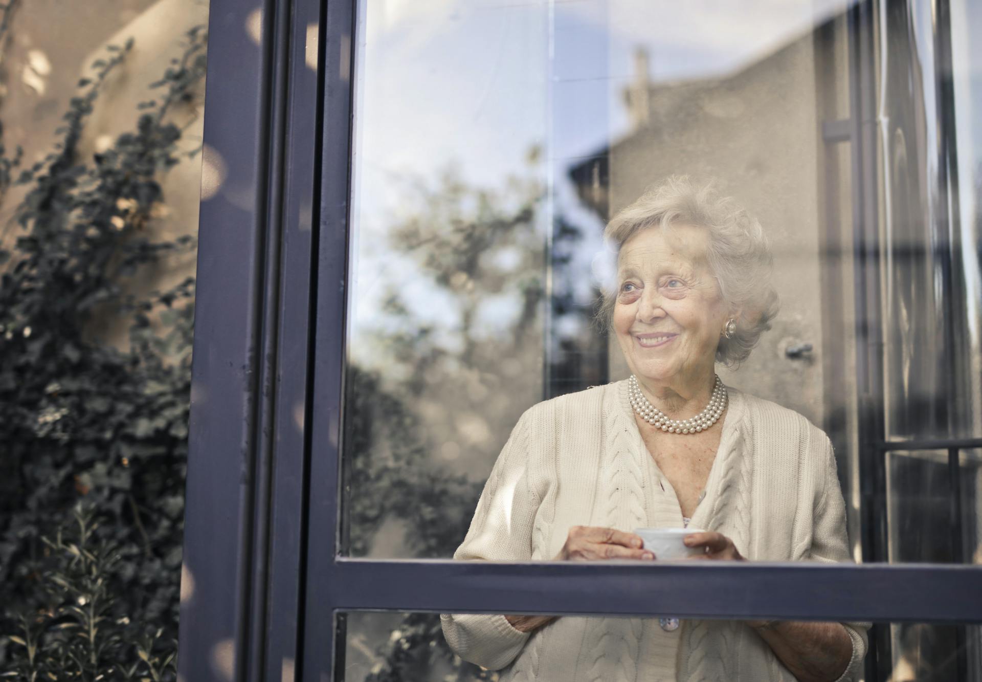 Una anciana delante de una cristalera | Fuente: Pexels