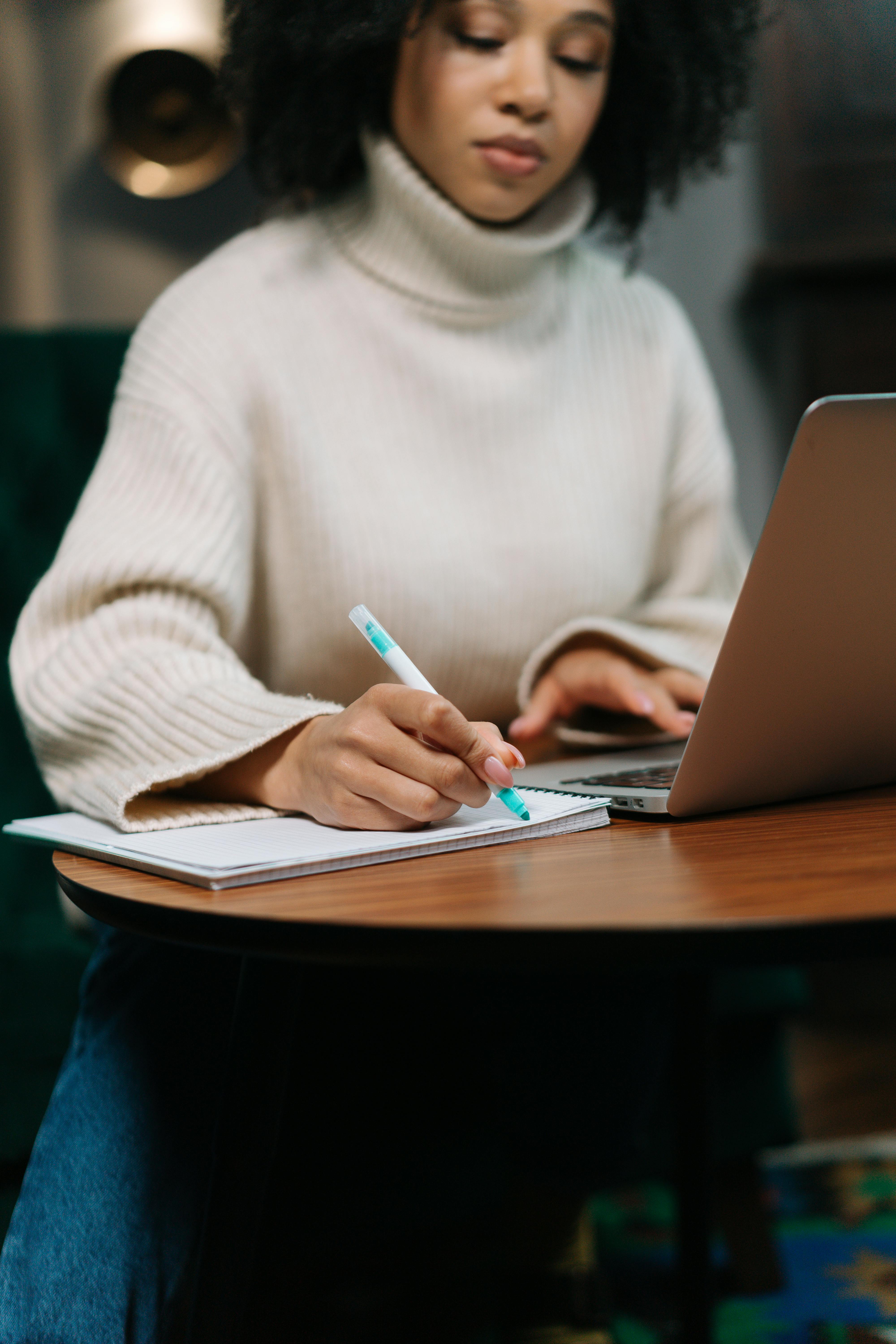 Una mujer escribiendo en el trabajo | Fuente: Pexels