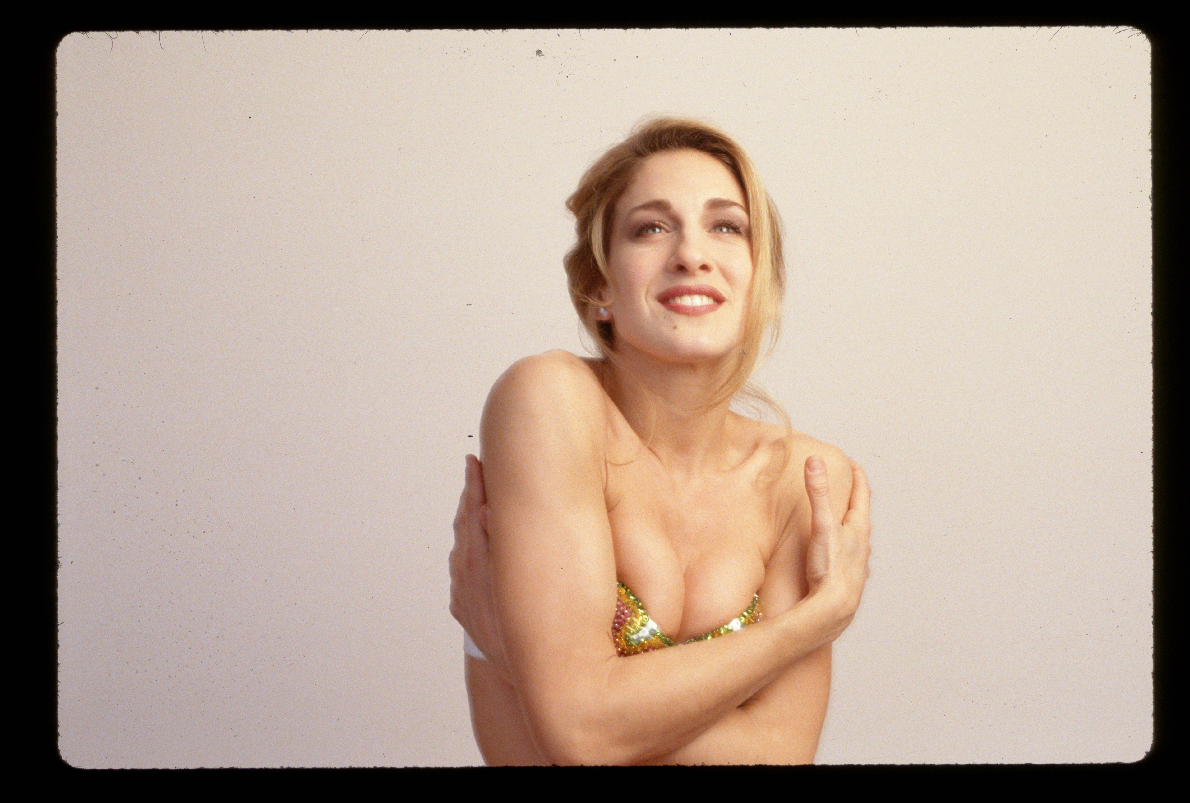 Sarah Jessica Parker aparece de cintura para arriba, con los brazos cruzados delante de ella en un bikini de lentejuelas en 1990. | FueFotonte: Getty Images