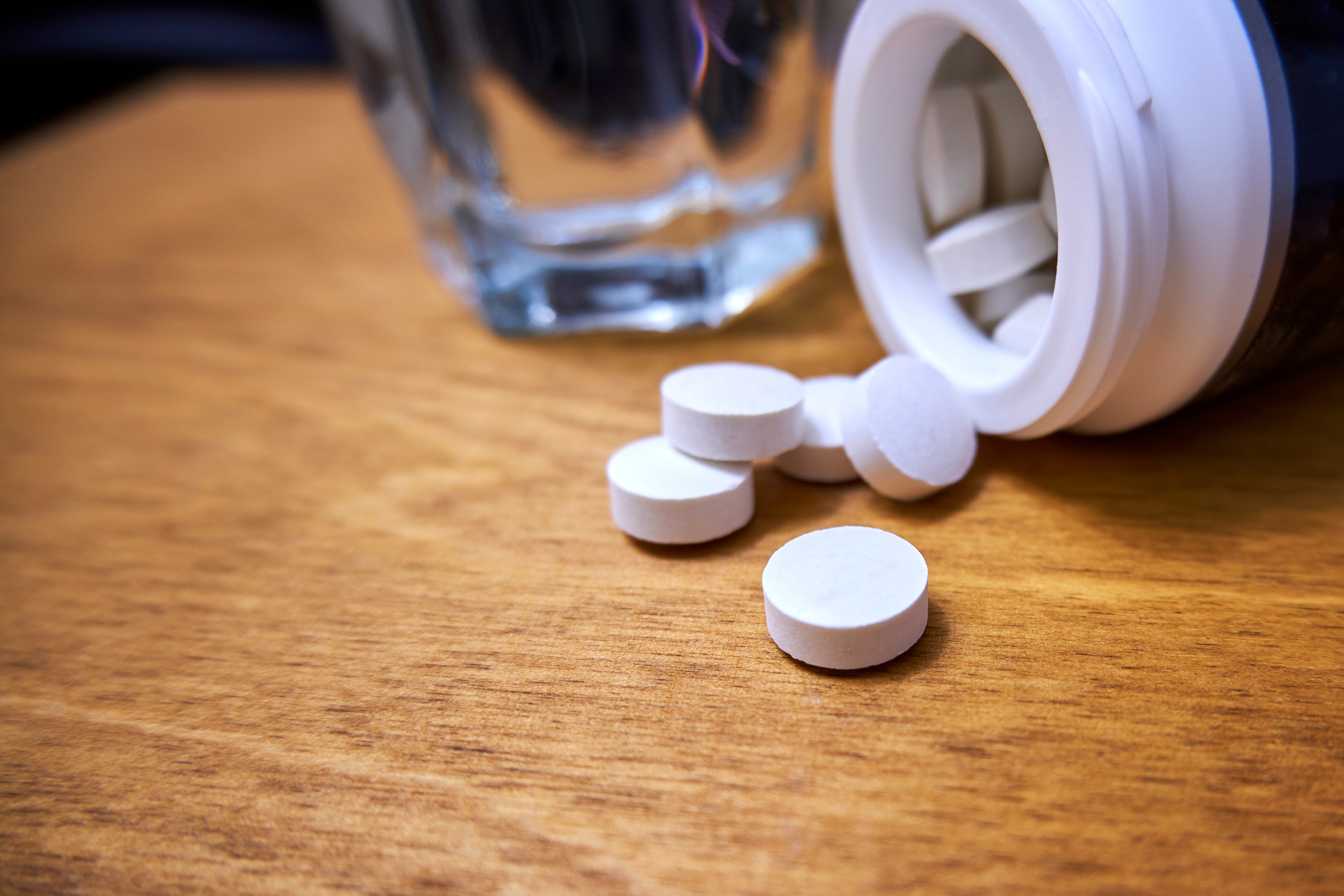Primer plano de las pastillas y el vial sobre la mesa. | Fuente: Shutterstock