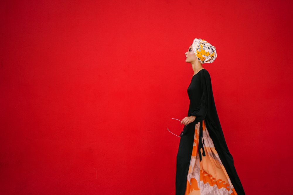 Retrato de moda de una mujer alta posando sobre un fondo rojo y liso. | Foto: Shutterstock