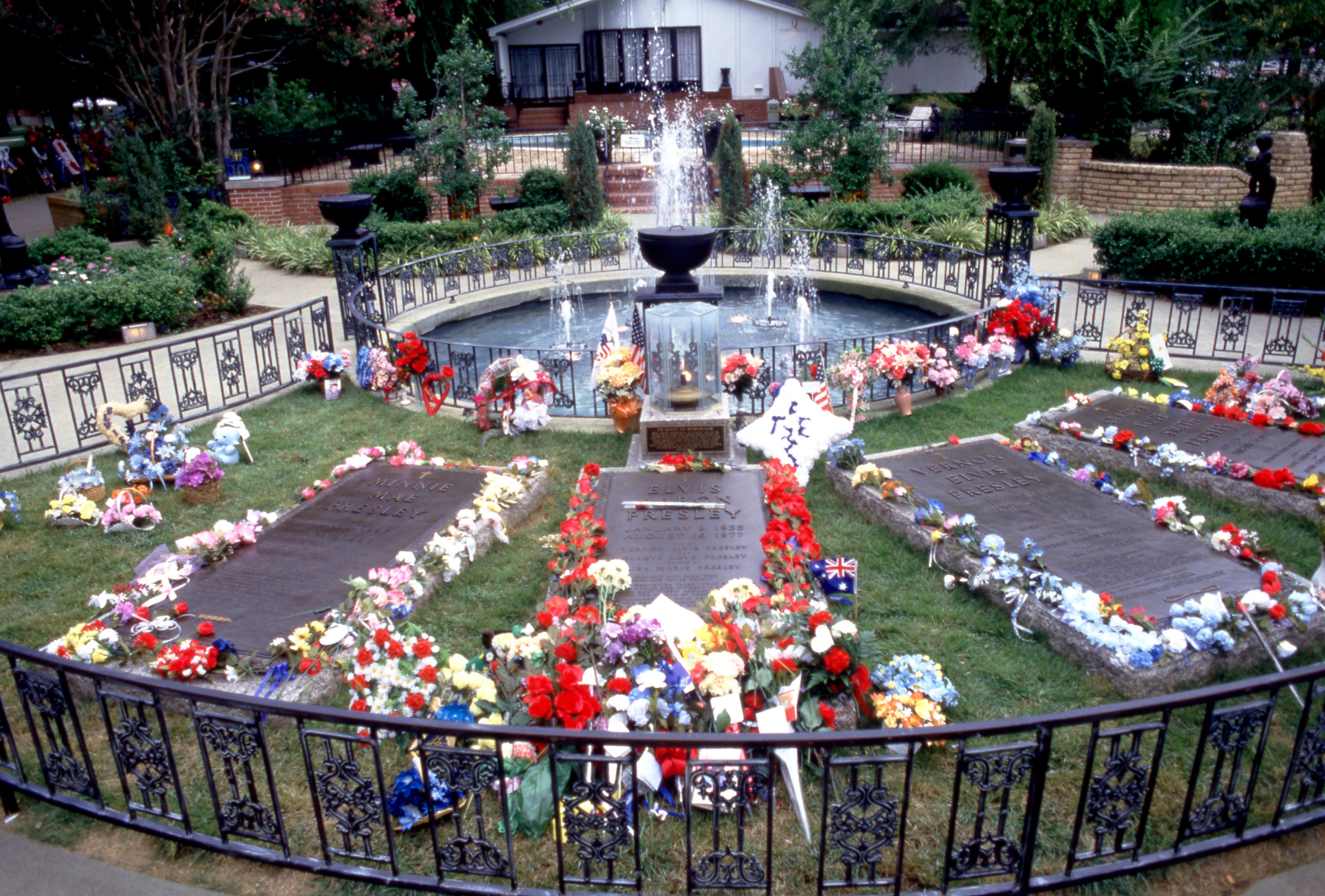 Las lápidas de Minnie Mae Presley, Elvis Aaron Presley, Vernon Elvis Presley y Gladys Love Smith Presley, rodeadas de flores, regalos y decoraciones, antes del décimo aniversario de la muerte de Elvis, el 15 de agosto de 1987 en Graceland en Memphis, Tennessee, Estados Unidos. | Foto: Getty Images