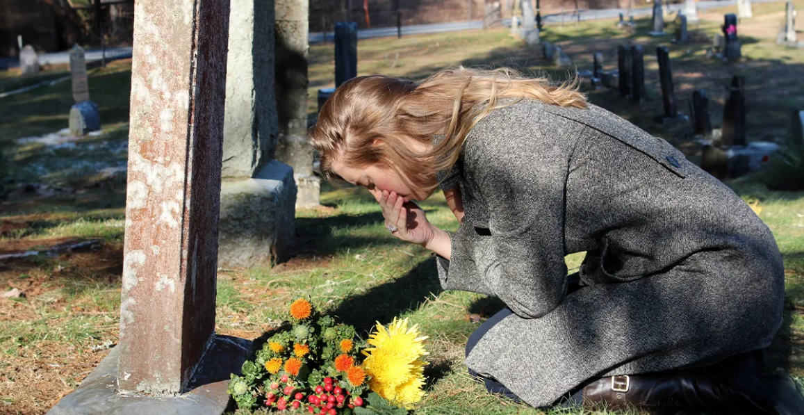 Mujer afligida ante la tumba | Foto: Shutterstock