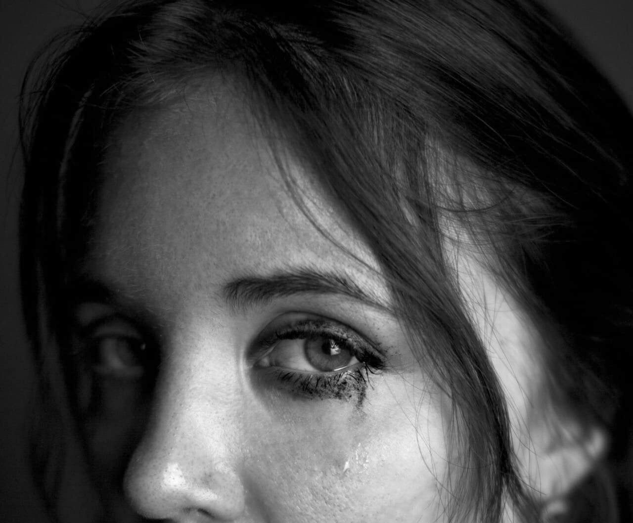 Toma en escala de grises de los ojos llorosos de una mujer triste | Fuente: Pexels