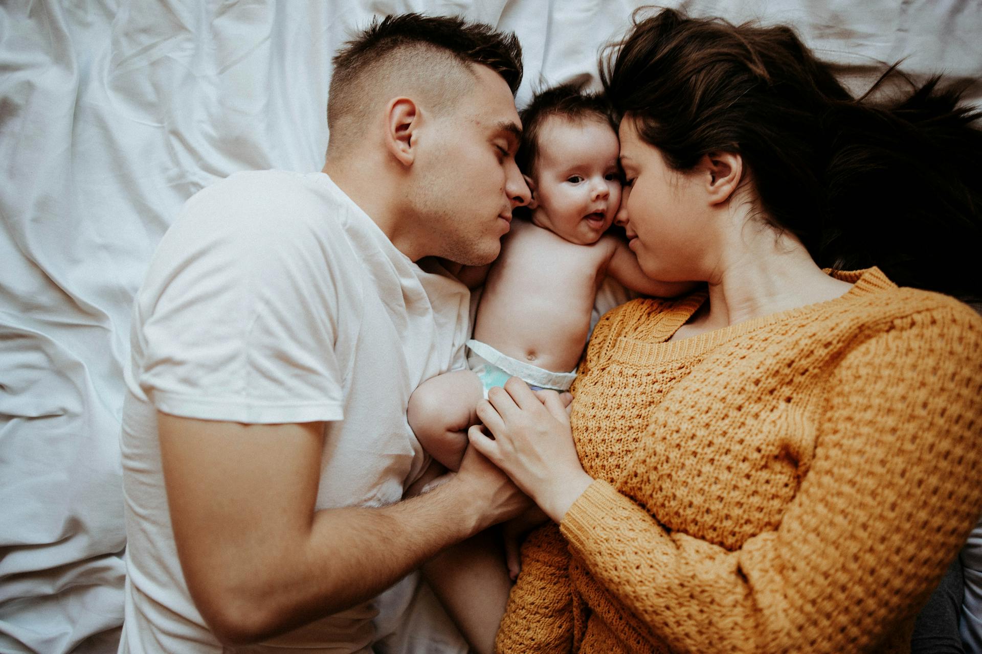 Pareja en la cama con un bebé | Foto: Pexels