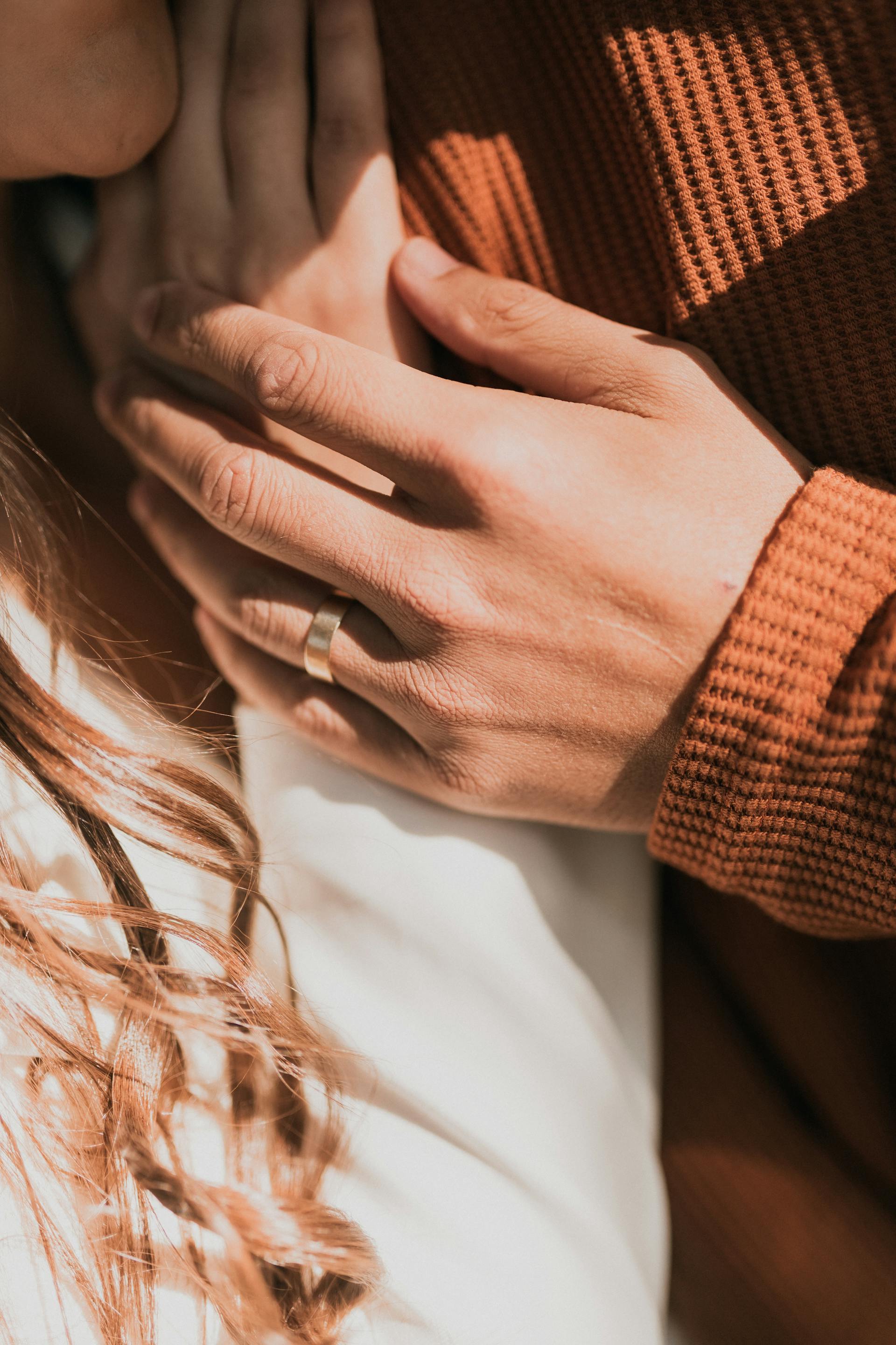 Mano masculina sobre la mano de una mujer | Fuente: Pexels