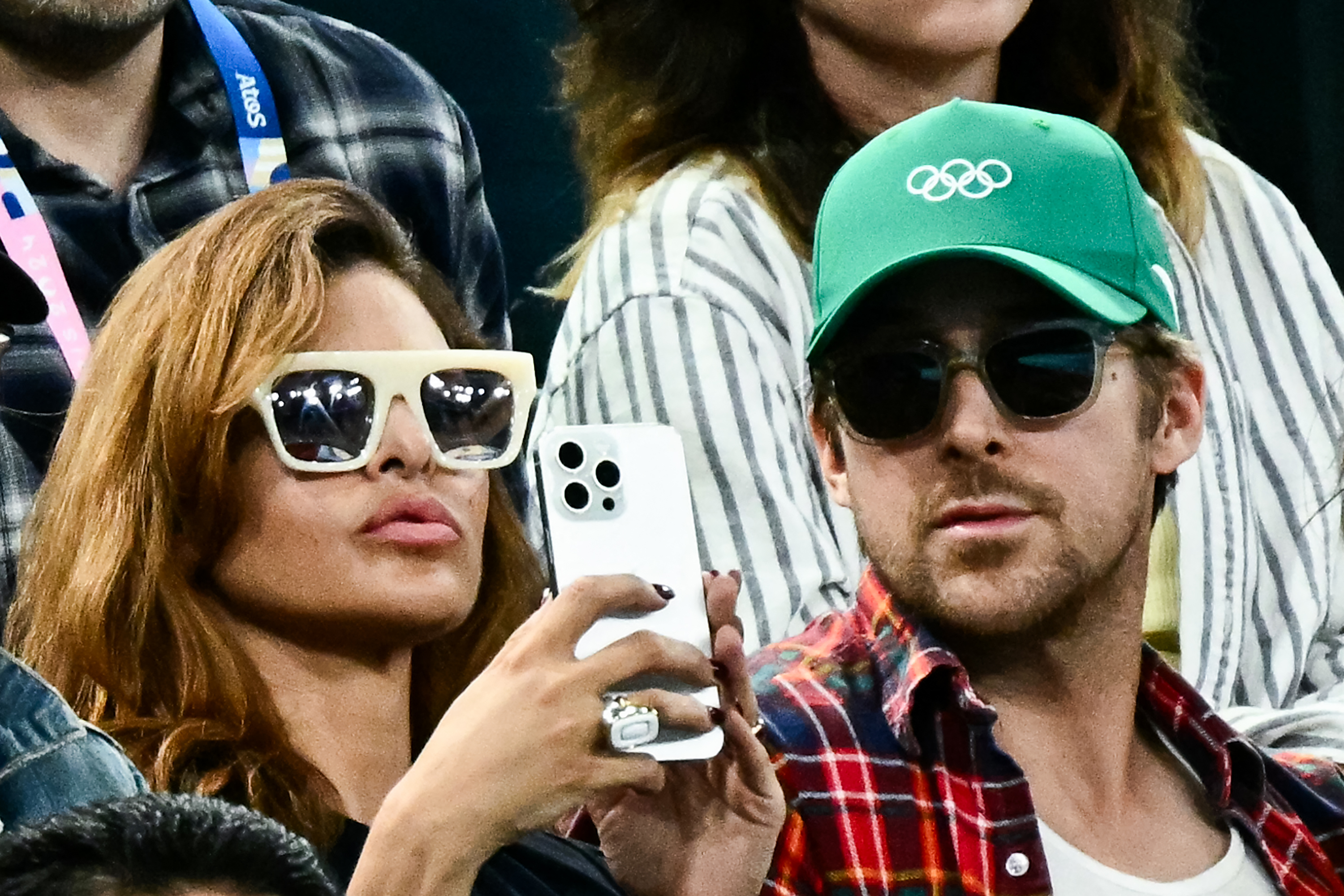 Eva Mendes sostiene su teléfono junto a Ryan Gosling mientras ve la final femenina de barras asimétricas en el Bercy Arena durante los Juegos Olímpicos de París 2024 el 4 de agosto de 2024 | Fuente: Getty Images