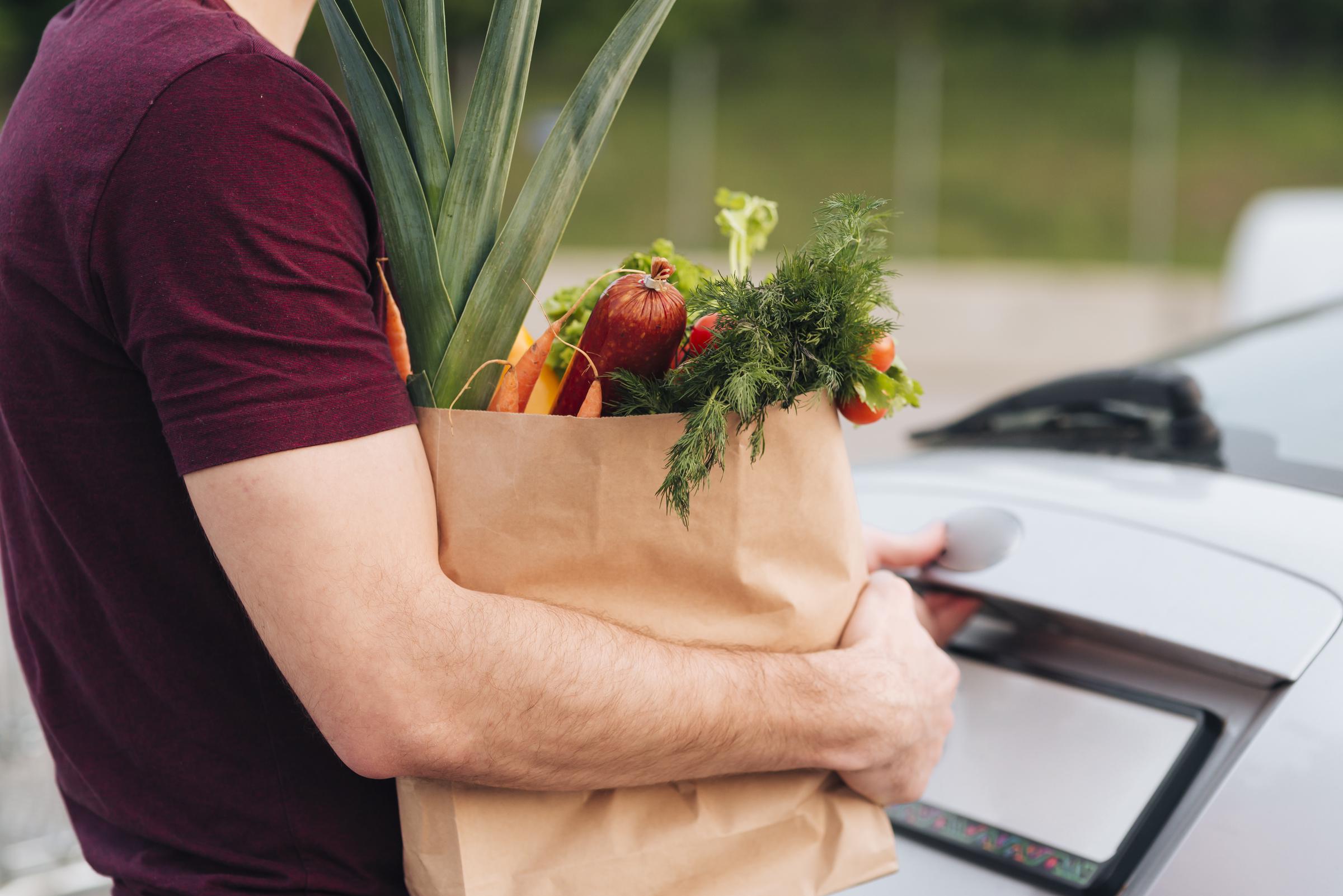 Hombre sujetando una bolsa de la compra | Fuente: Freepik