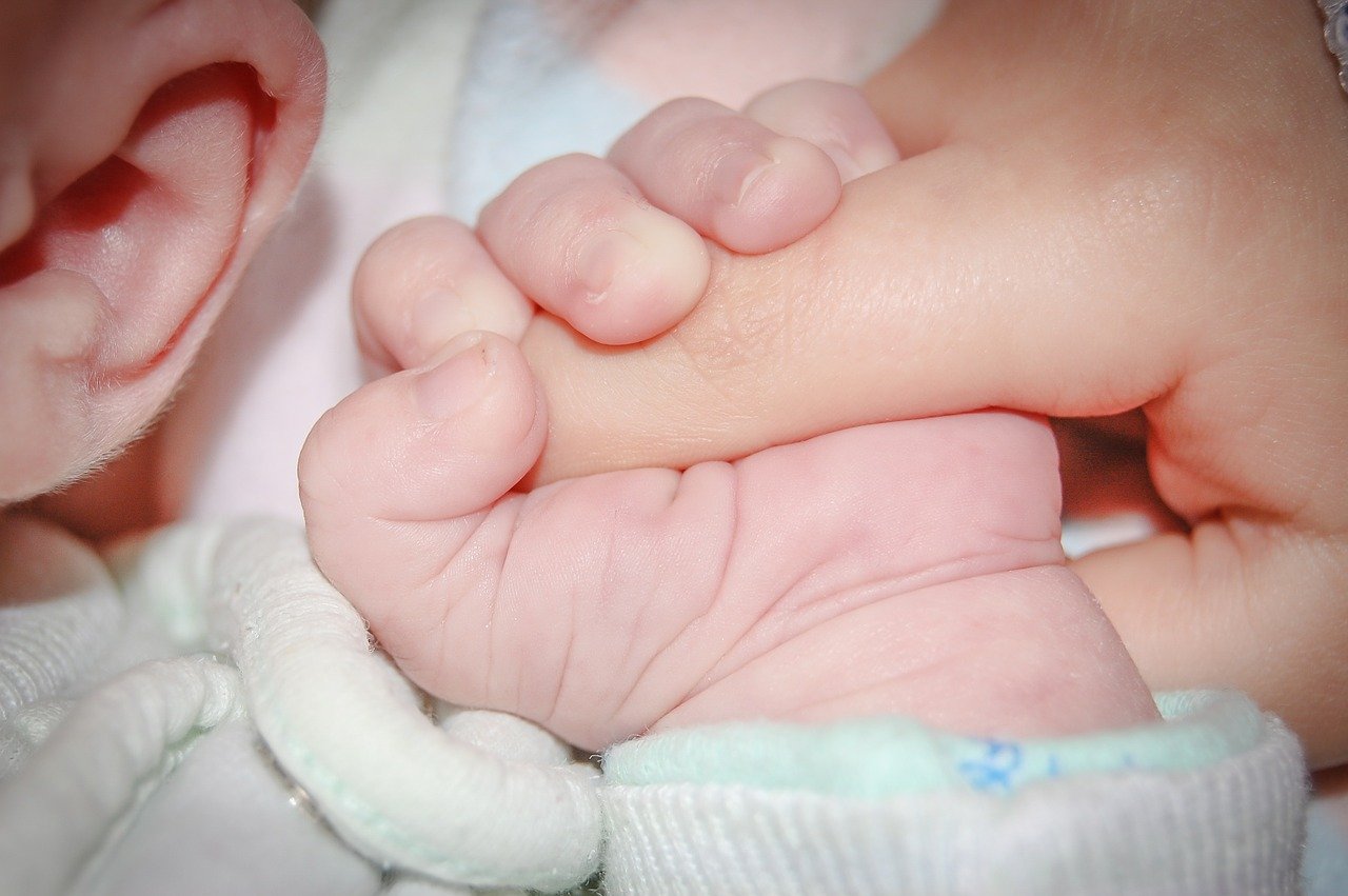 Bebé sosteniendo el dedo de su madre. | Foto: Pixabay
