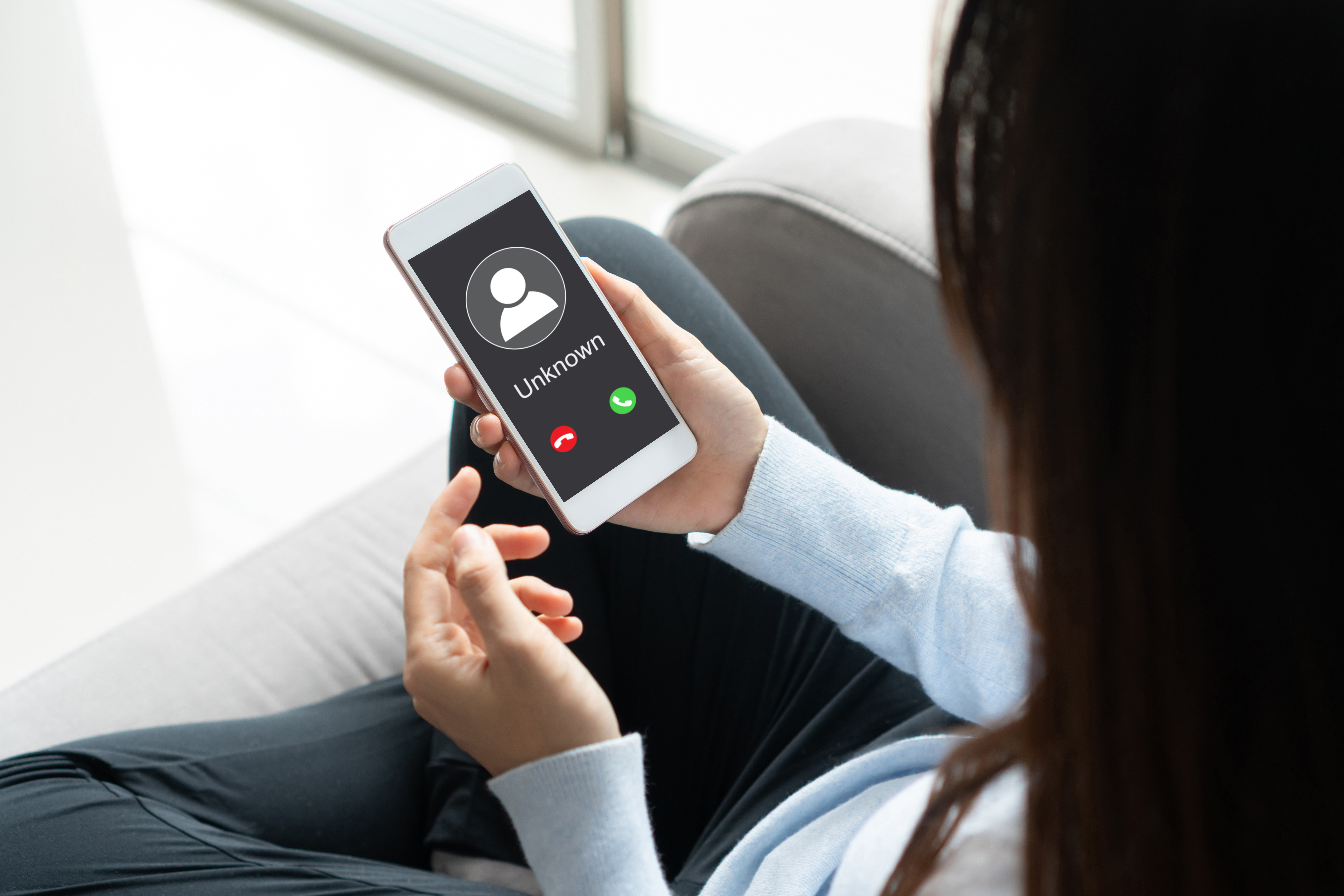 Una mujer sostiene su teléfono con la pantalla mostrando una llamada entrante | Fuente: Getty Images