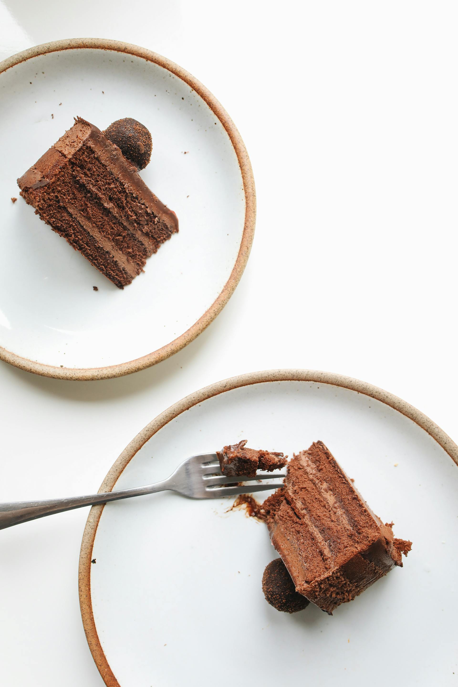 Porciones de pastel de chocolate en platos | Fuente: Pexels