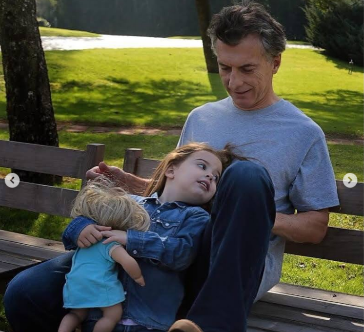 En una tarde al aire libre, Mauricio Macri disfruta de un momento de descanso en un banco de madera de jardín junto a Antonia. La niña, vestida con camisa de mezclilla, se recuesta sobre su regazo abrazando su muñeca, mientras su padre, con remera gris y jeans, la contempla con ternura. | Fuente: Instagram/mauriciomacri