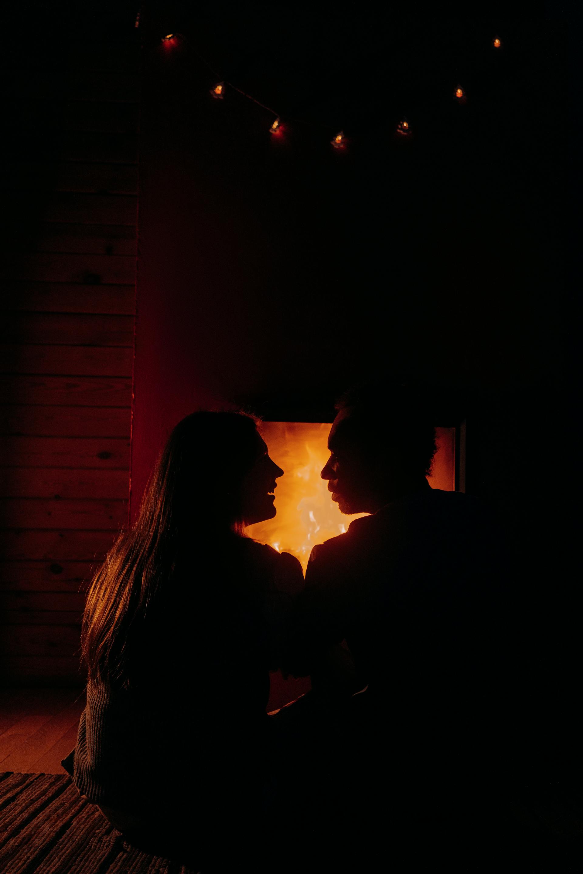 Una pareja sentada frente al fuego | Fuente: Pexels