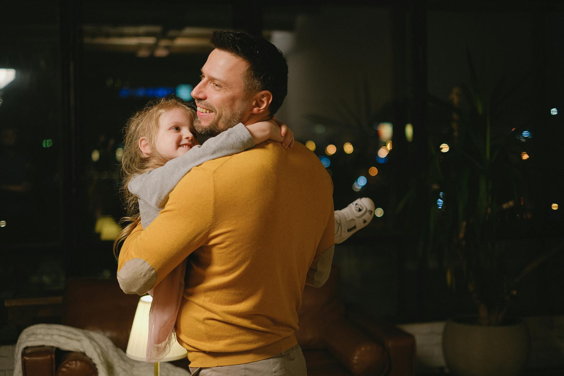 Un padre sonríe mientras lleva a su hija pequeña | Fuente: Pexels