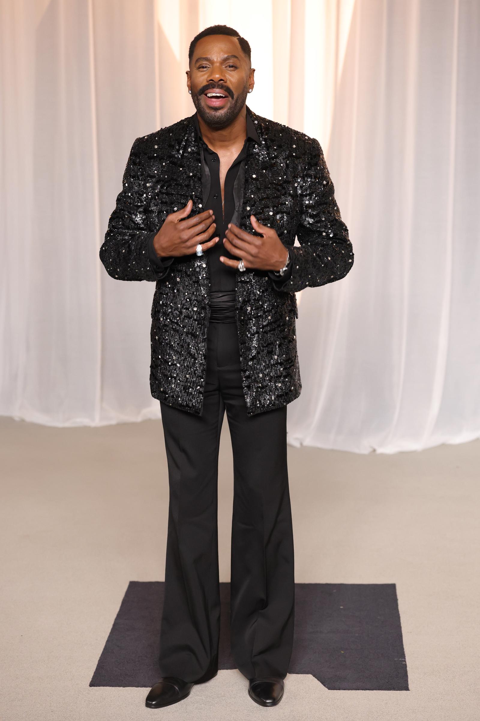 Colman Domingo acapara todas las miradas con un conjunto negro de corte impecable, compuesto por una chaqueta brillante con lentejuelas, unos pantalones holgados de pierna ancha y unos llamativos anillos que brillan con luz propia. Con el cuello de la camisa bien abierto y esbozando una amplia sonrisa, el actor combina una sofisticación refinada con su característico estilo atrevido mientras celebra haber recibido el Premio Vantage.
