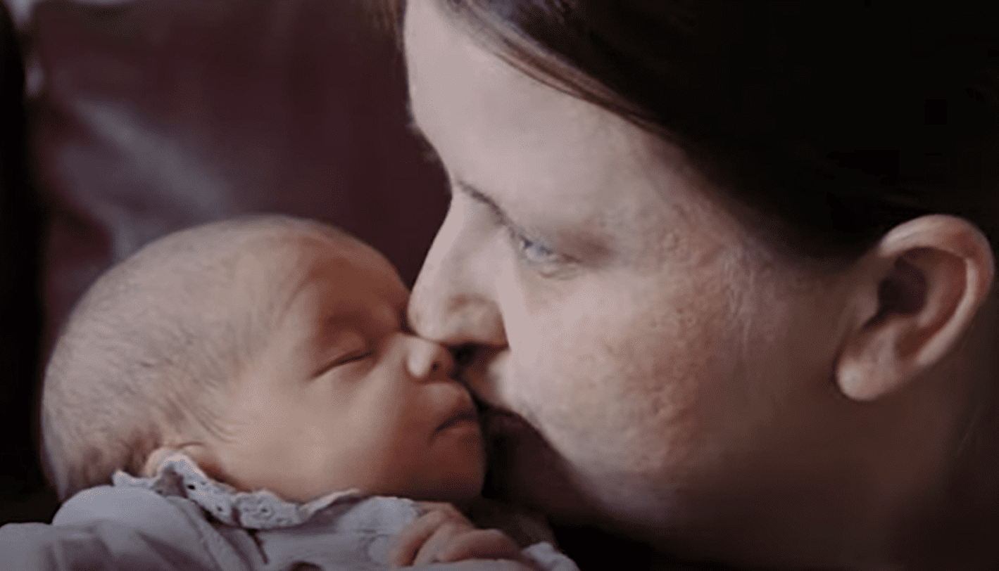 Nicola Thomas besando a su recién nacida Baylee-Rae en sus mejillas. | Foto: Youtube.com/Wales Online