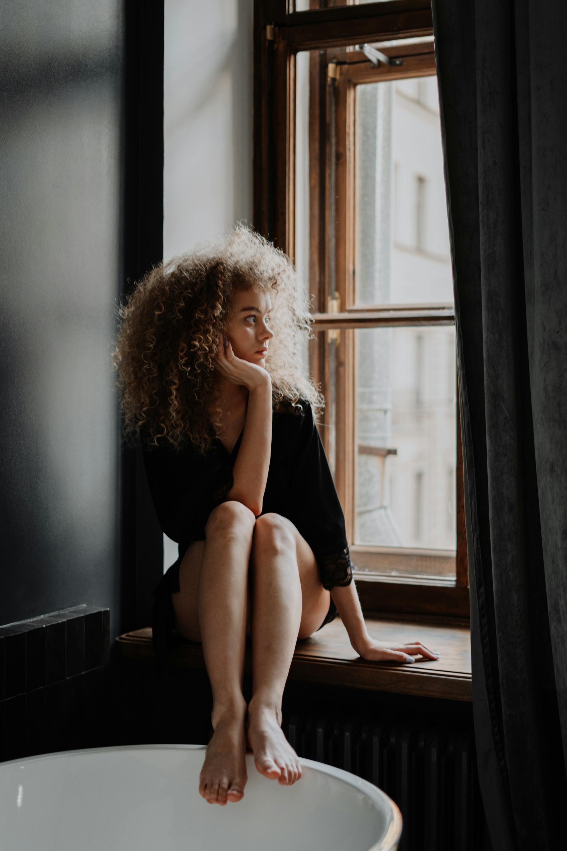 Una mujer mirando por una ventana | Fuente: Pexels