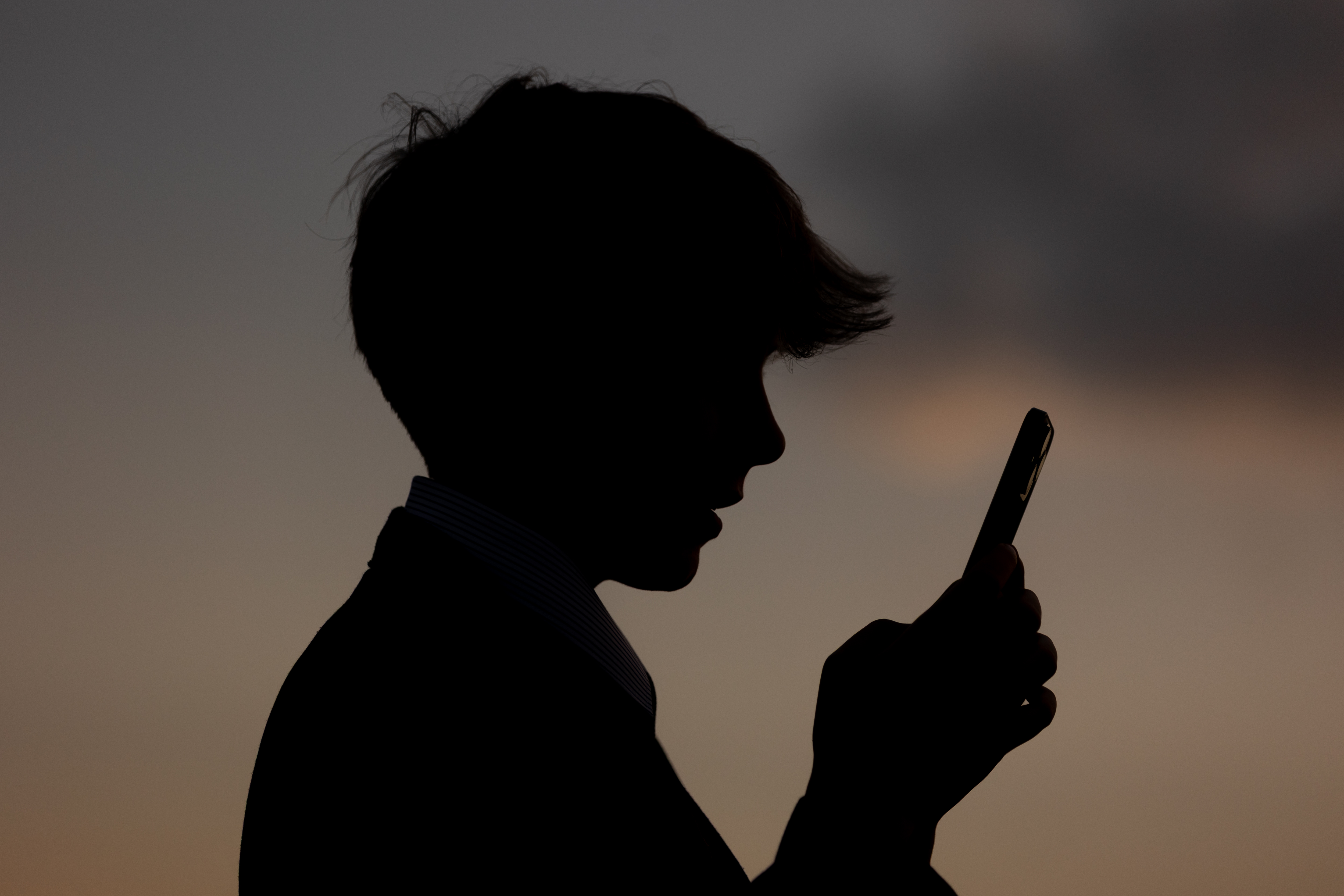 Chico mira la pantalla de un teléfono | Fuente: Getty Images