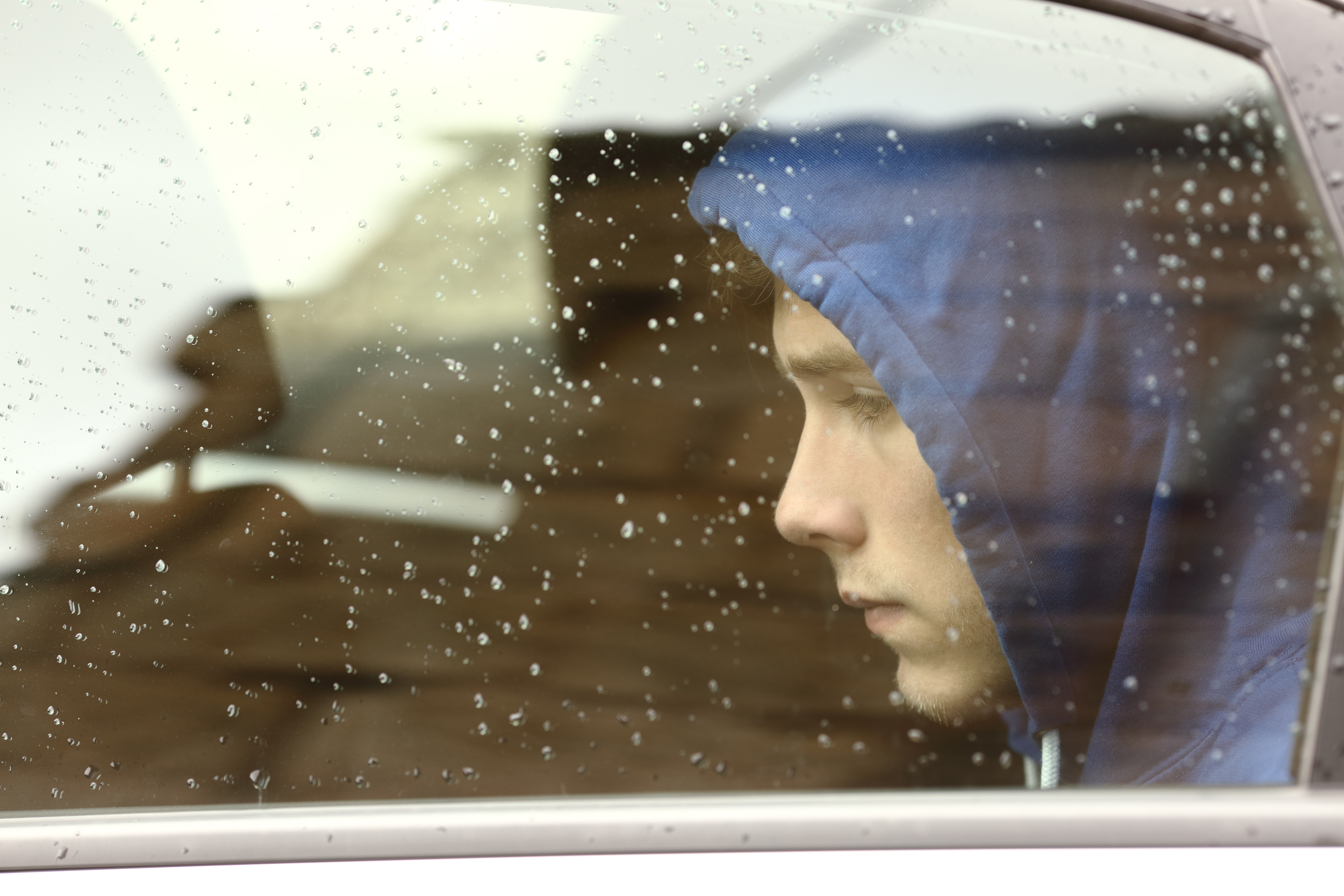 Un joven triste sentado en un Automóvil | Fuente: Shutterstock