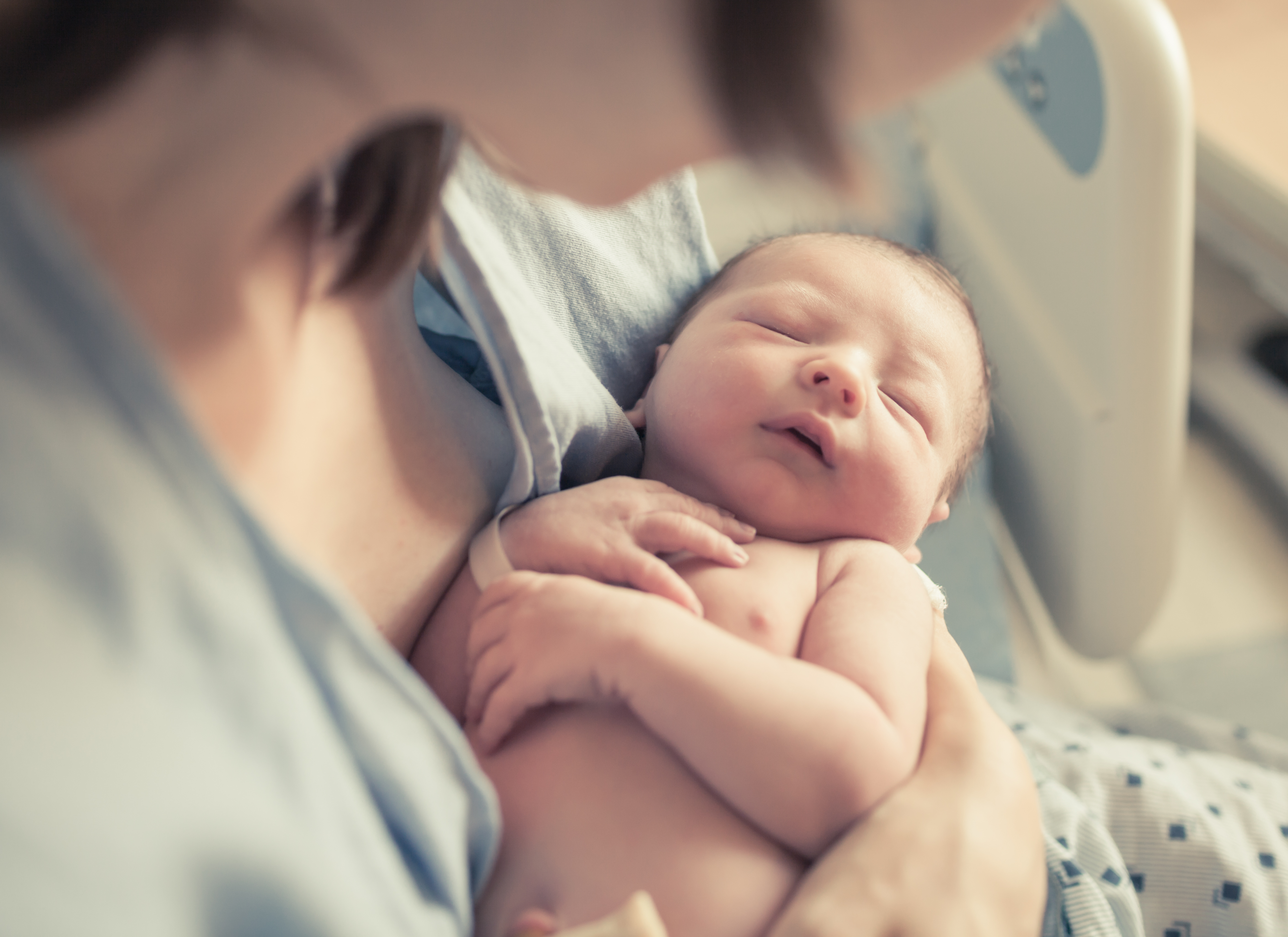 Foto en primer plano de una mujer sosteniendo a su bebé recién nacido | Fuente: Shutterstock