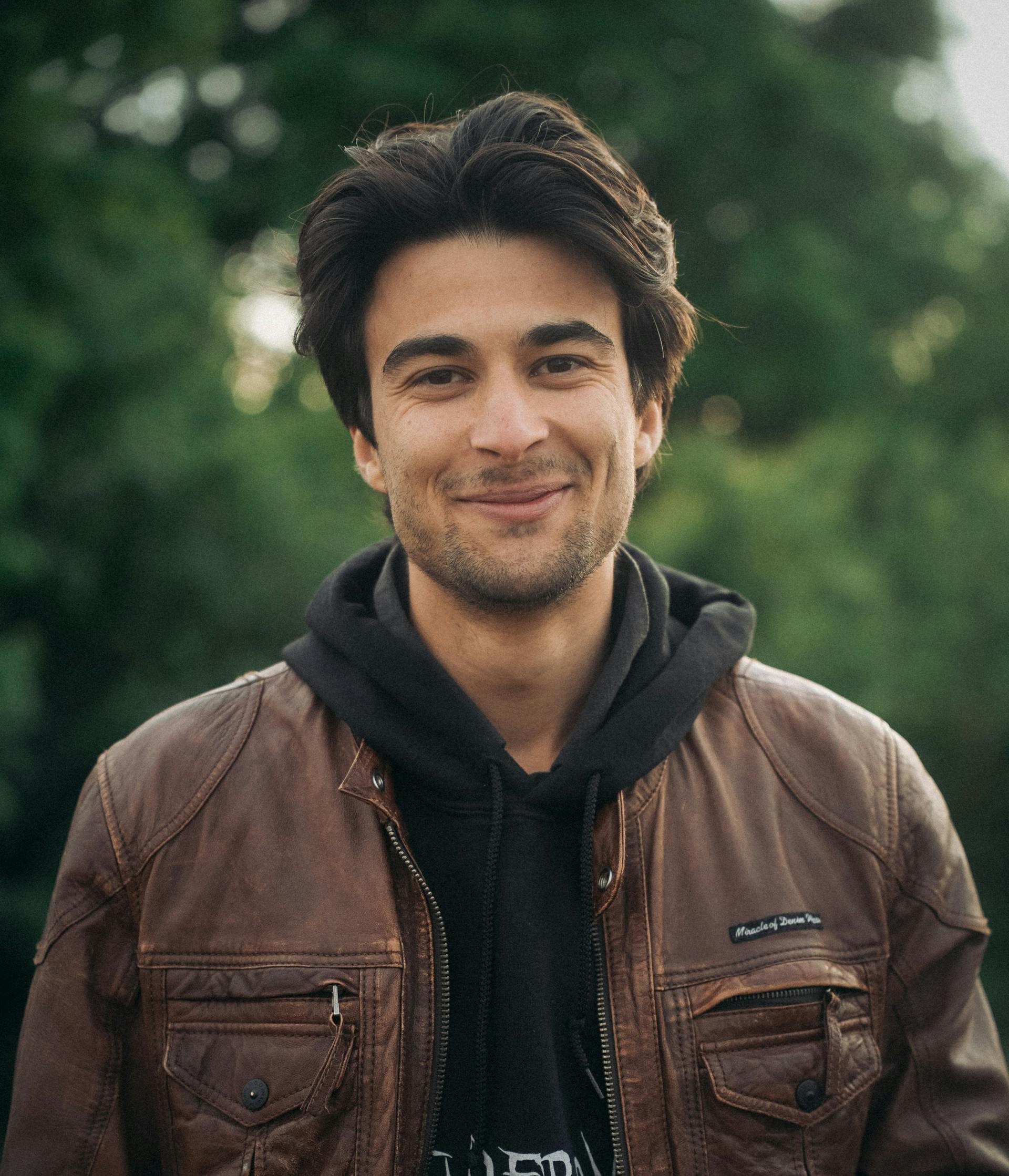Un hombre sonriente con capucha | Fuente: Pexels