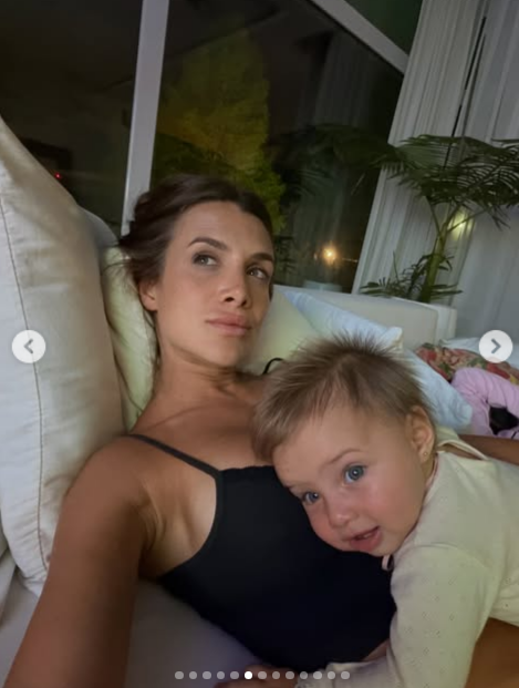 Camila Homs compartió un momento íntimo de relax recostada sobre almohadones claros mientras su pequeña hija descansaba apoyada tiernamente sobre su pecho. La modelo posó al natural con un top negro de tirantes finos y el cabello recogido, mientras la bebé lució una prenda de dormir clara con una expresión dulce frente a la cámara. | Fuente: Instagram/camihoms