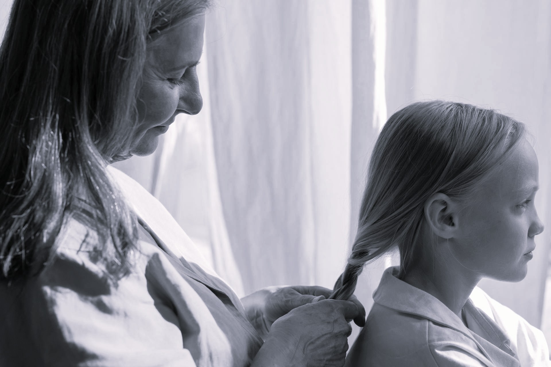 Una abuela trenzando el pelo de su nieta | Fuente: Pexels