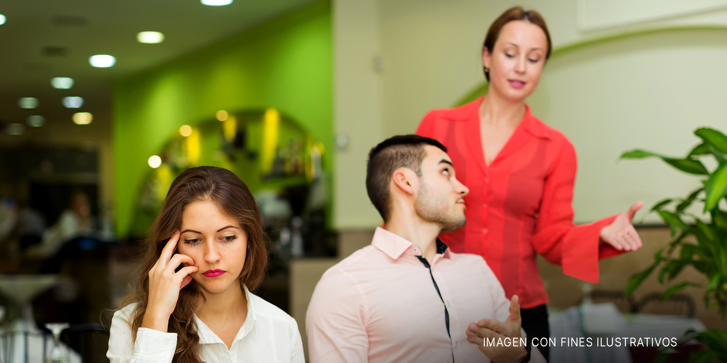Una mujer avergonzada en un restaurante donde su pareja está hablando con la camarera | Fuente: Shutterstock