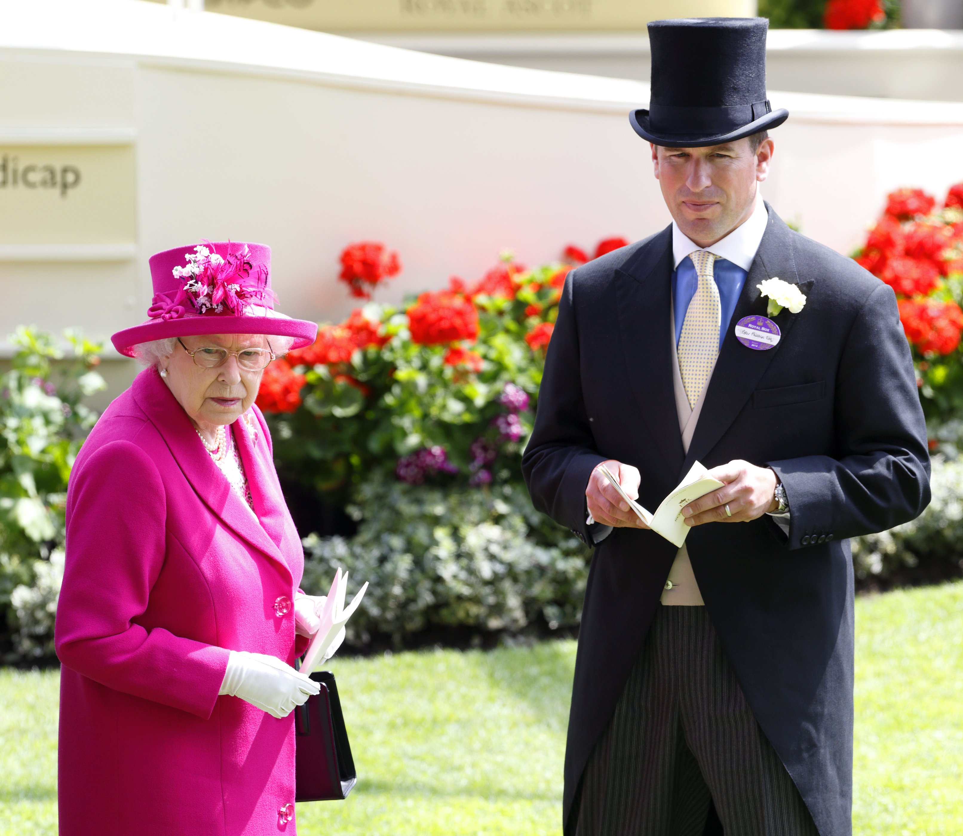 Elizabeth II y su nieto Peter Phillips observan a los caballos en la pista de desfile en el cuarto día de Royal Ascot en el hipódromo de Ascot el 20 de junio de 2014 en Inglaterra. | Foto: Getty Images