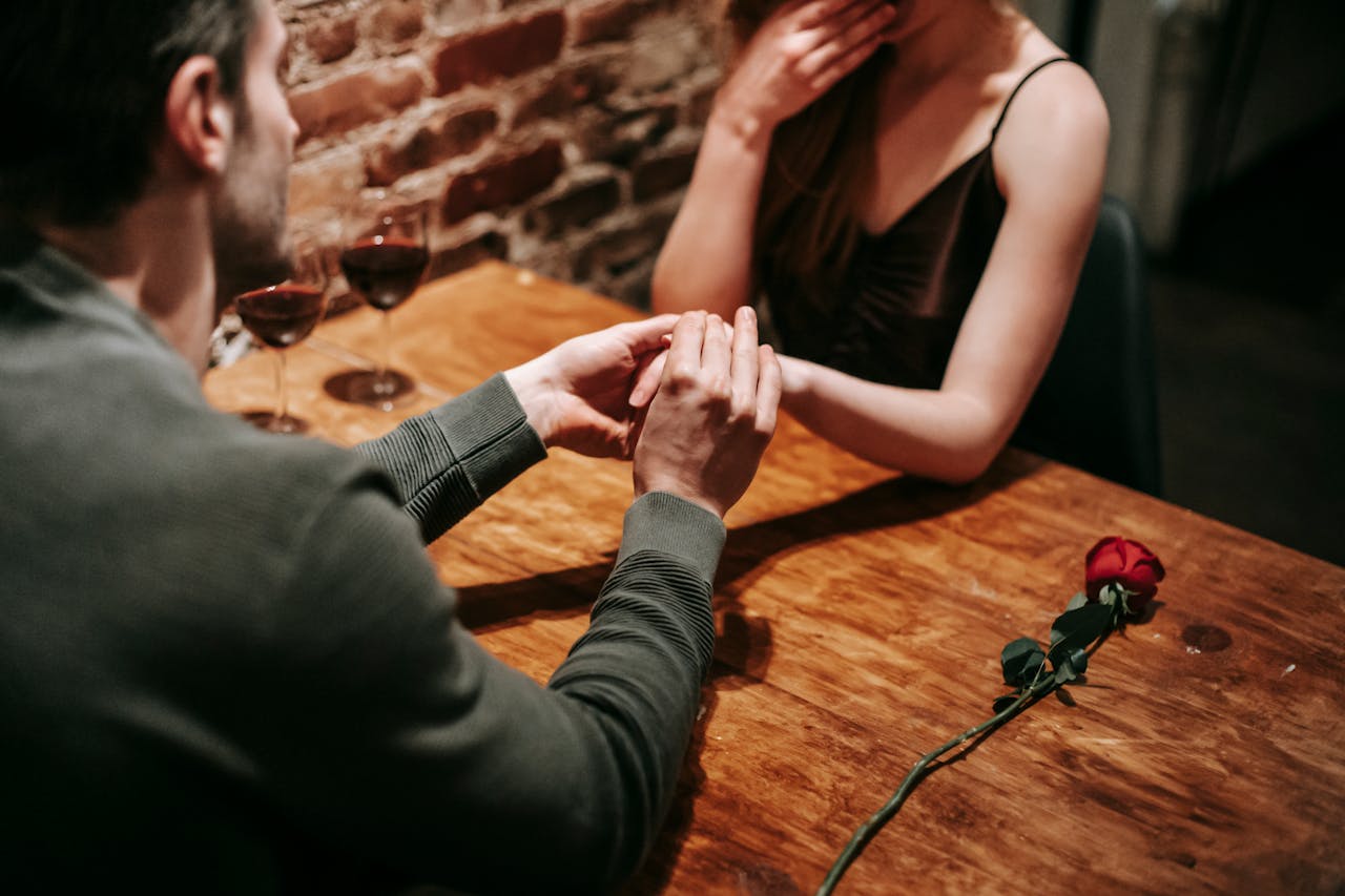 Un hombre tomando las manos a una mujer | Fuente: Pexels