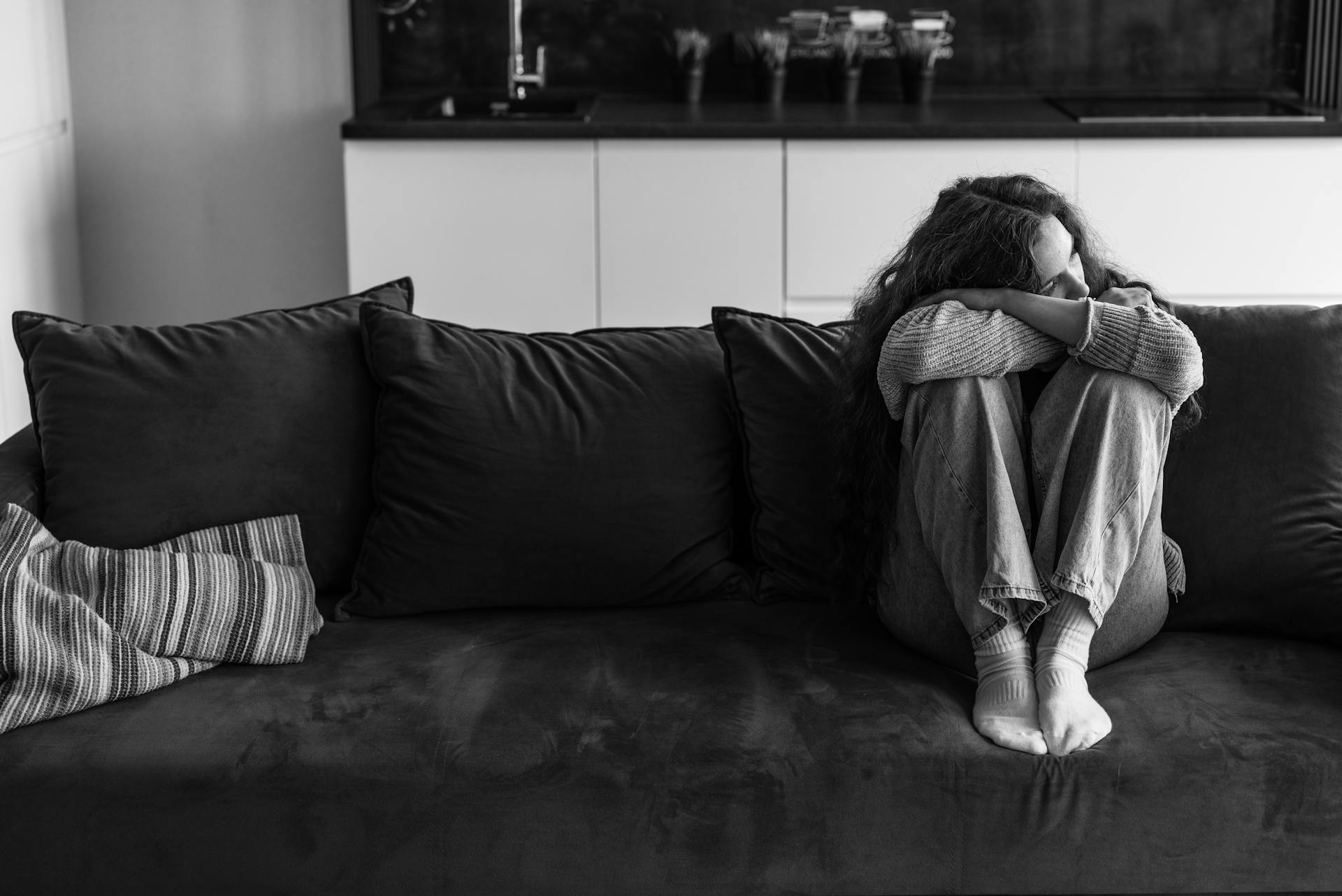 Una donna triste seduta sul divano | Fonte: Pexels