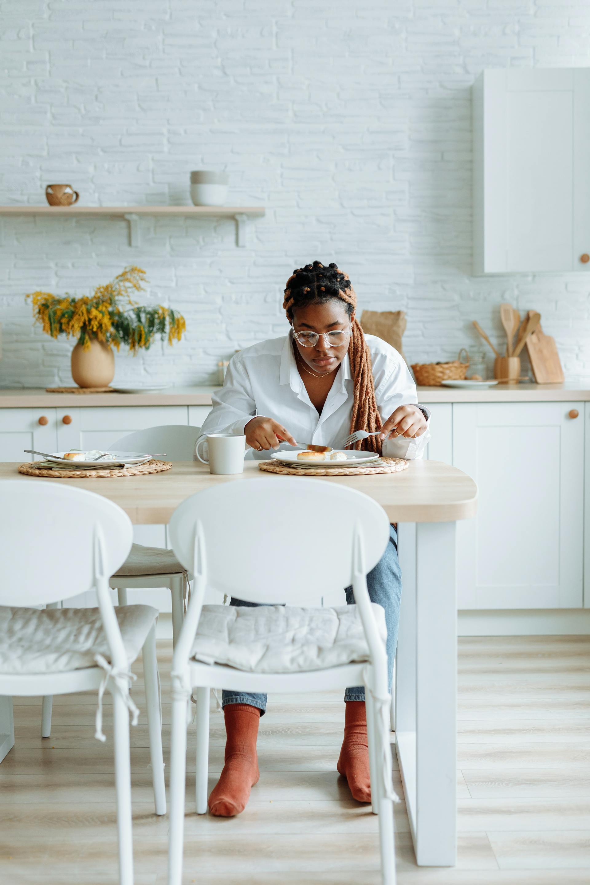 Una mujer comiendo en la cocina | Fuente: Pexels