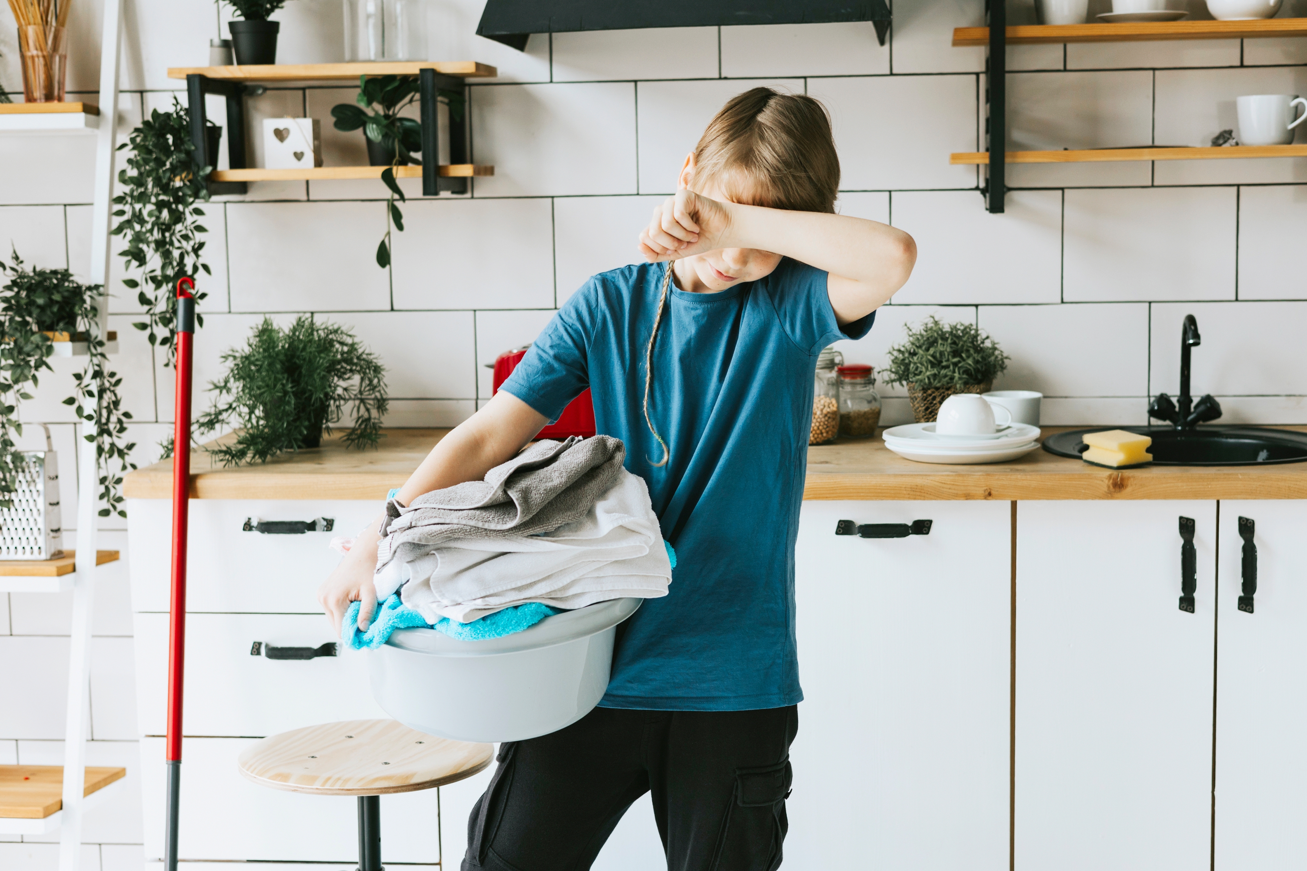 Niño llevando un cesto de ropa sucia. | Foto: Shutterstock