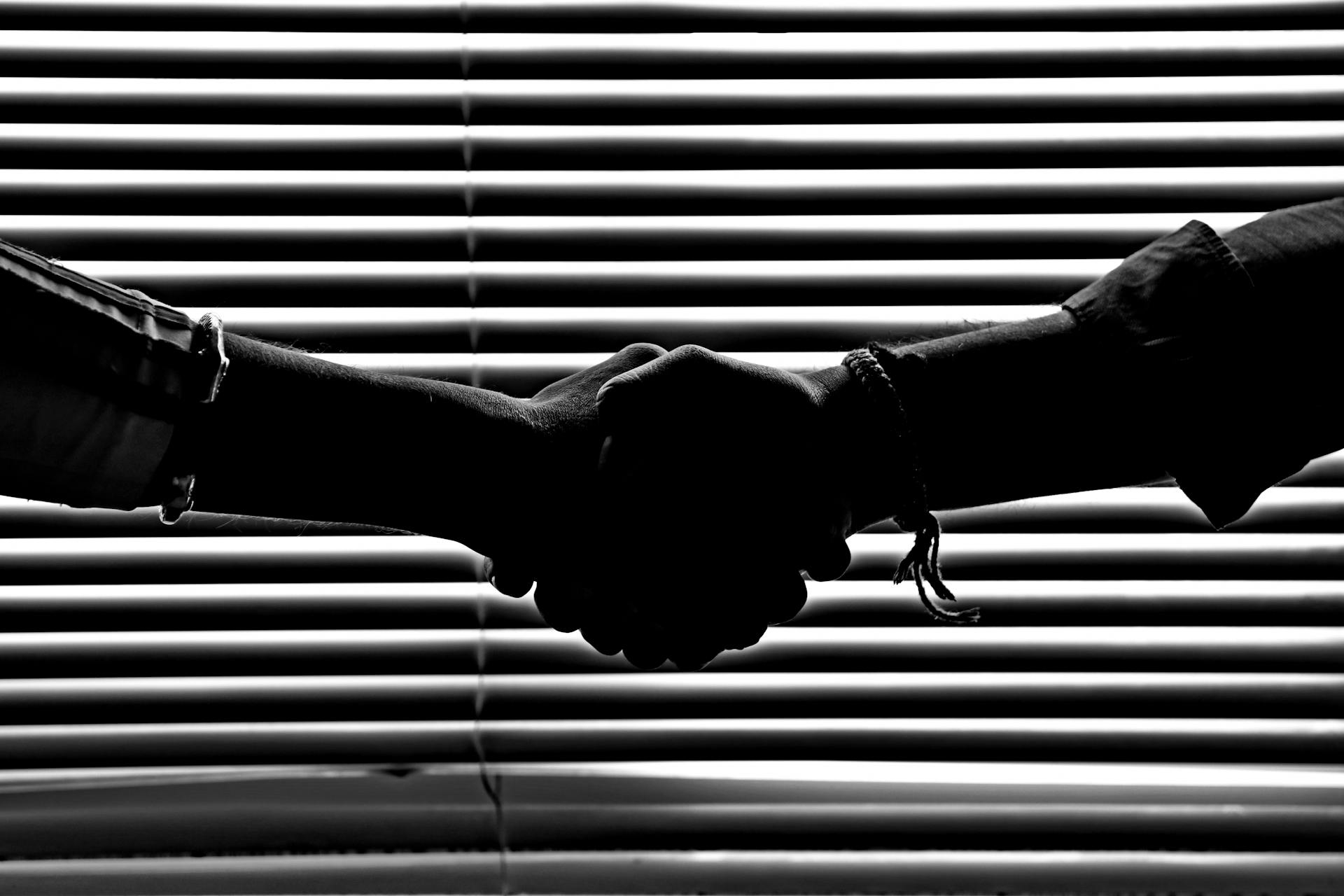 Primer plano de dos hombres dándose la mano | Fuente: Pexels