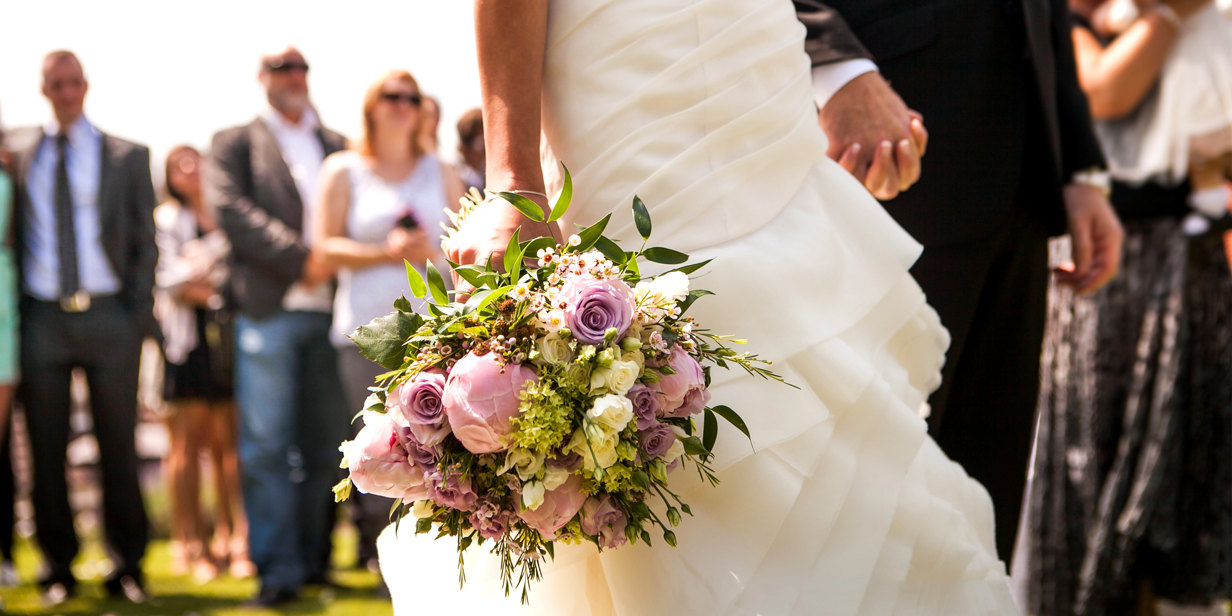 Una novia y un novio tomados de la mano en su boda | Fuente: Shutterstock