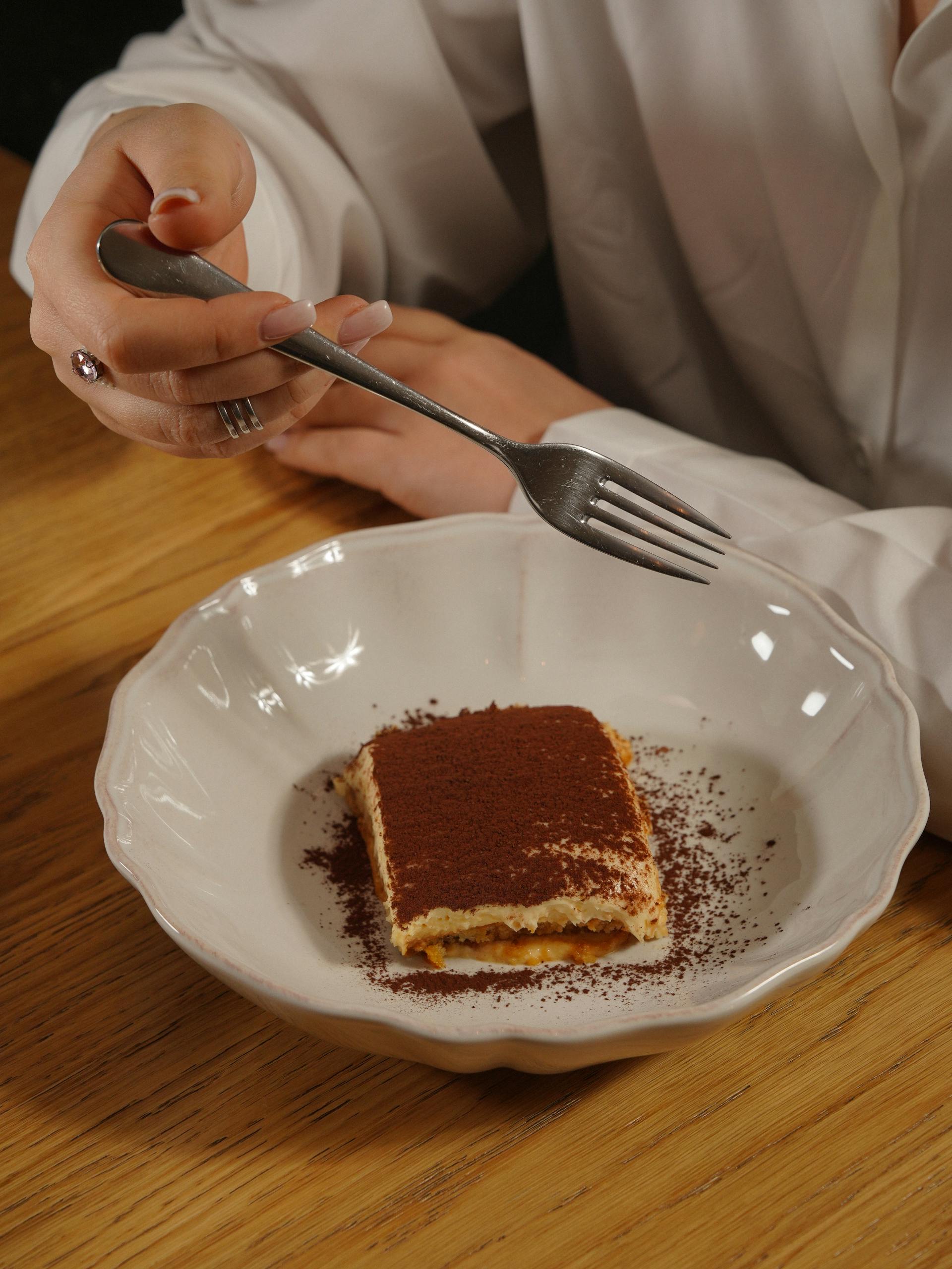 Una mujer comiendo tiramisú | Fuente: Pexels